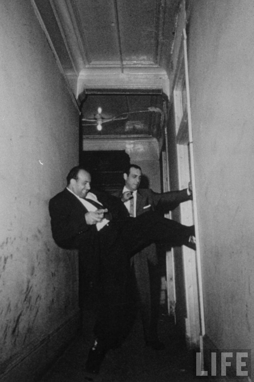 Chicago detectives forcing their way in the door of suspicious room., c