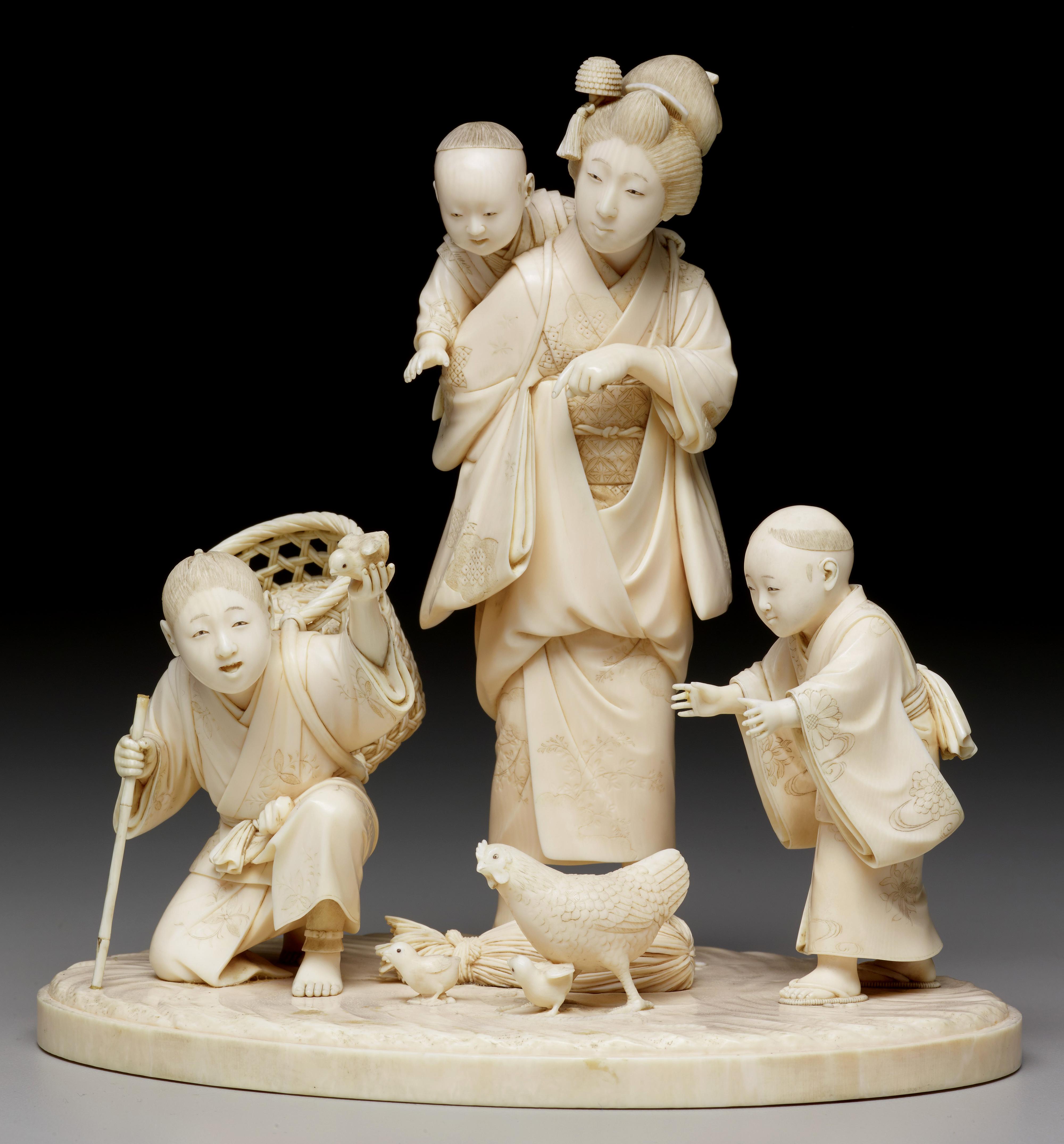 Ivory carving of a women and her children feeding chickens. Japan, 19th