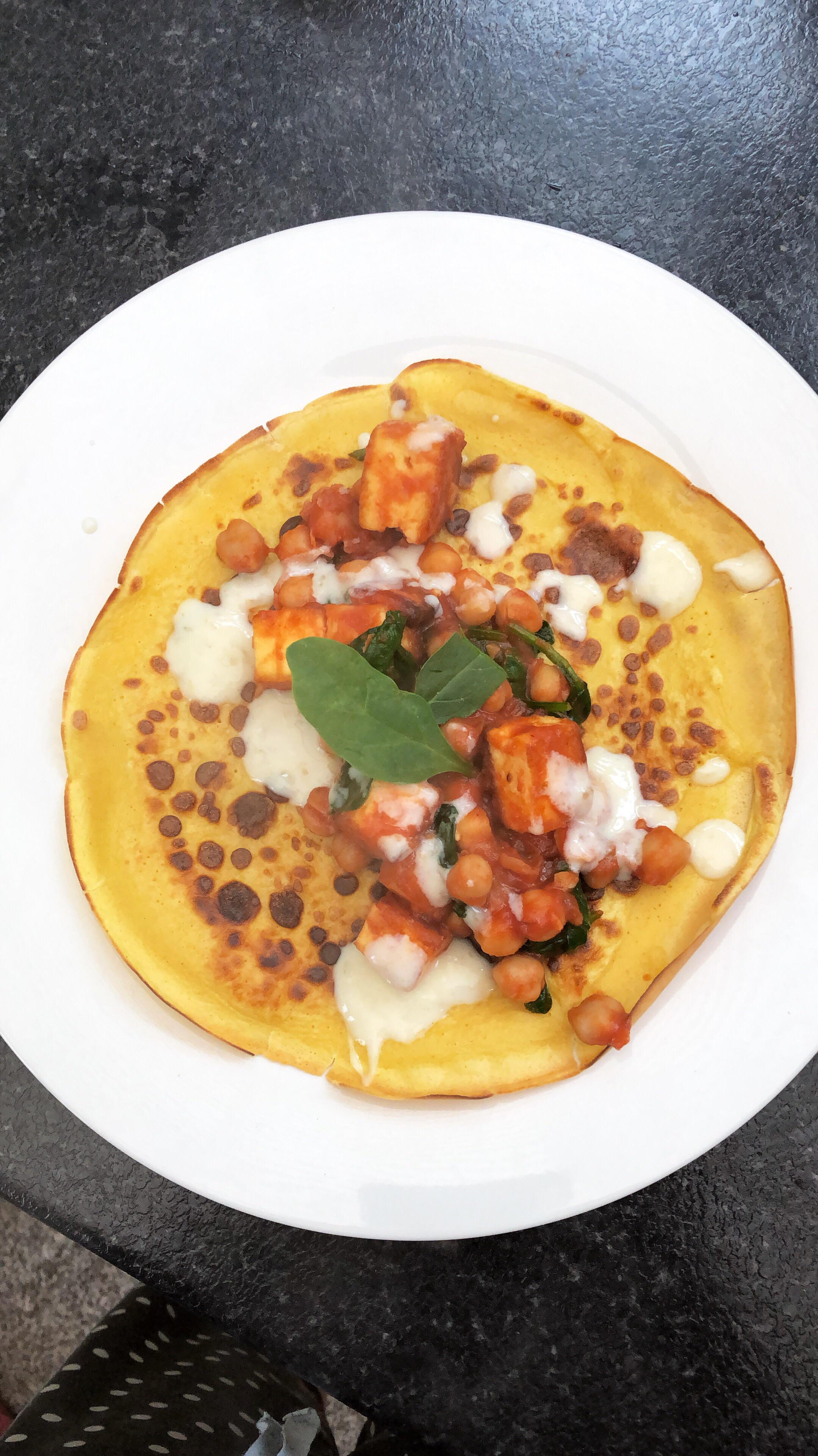 paneer, chickpea and spinach with a mango chutney yogurt on pancakes