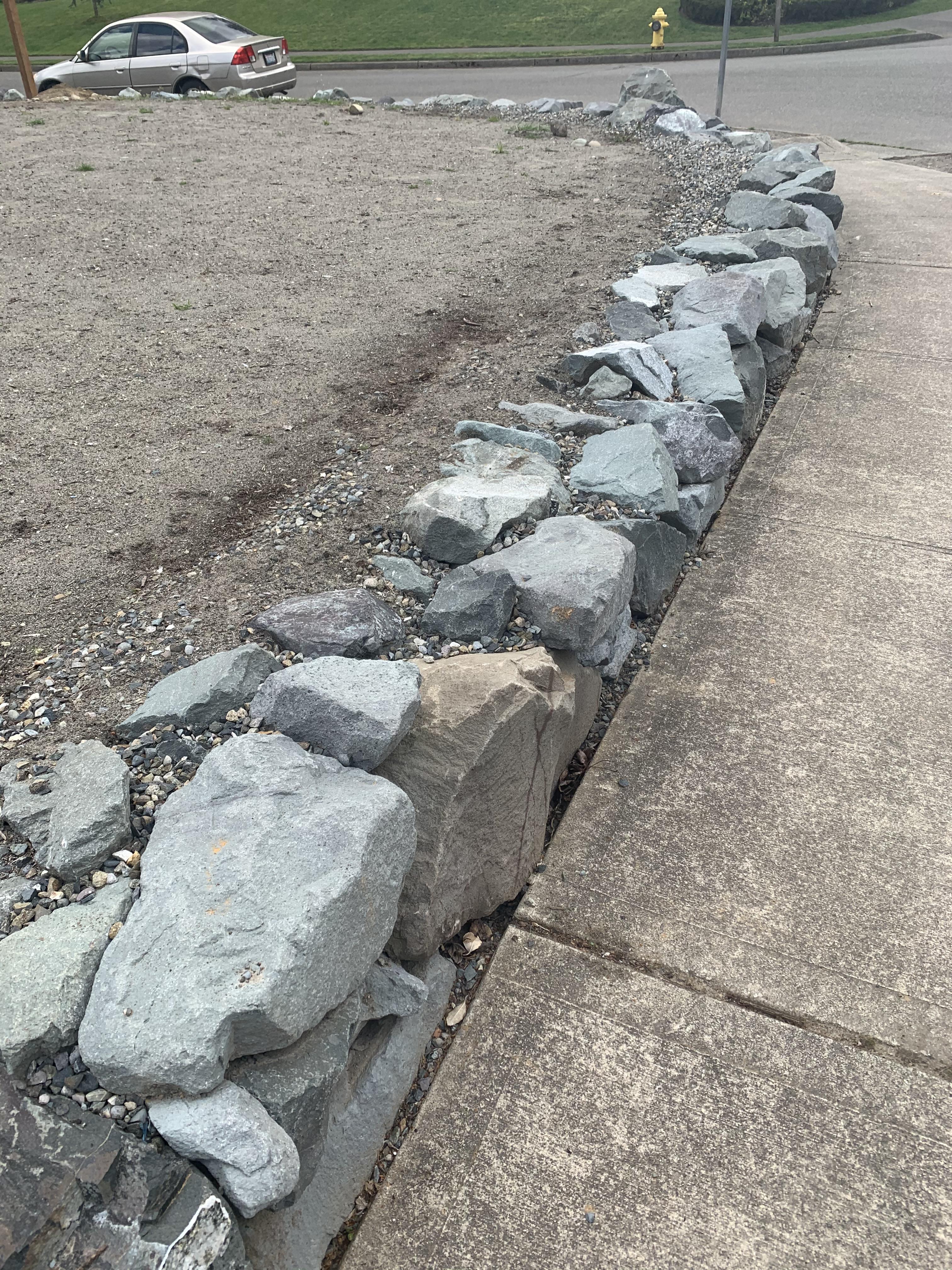 How do I transition from grass to rock wall? This is corner of front