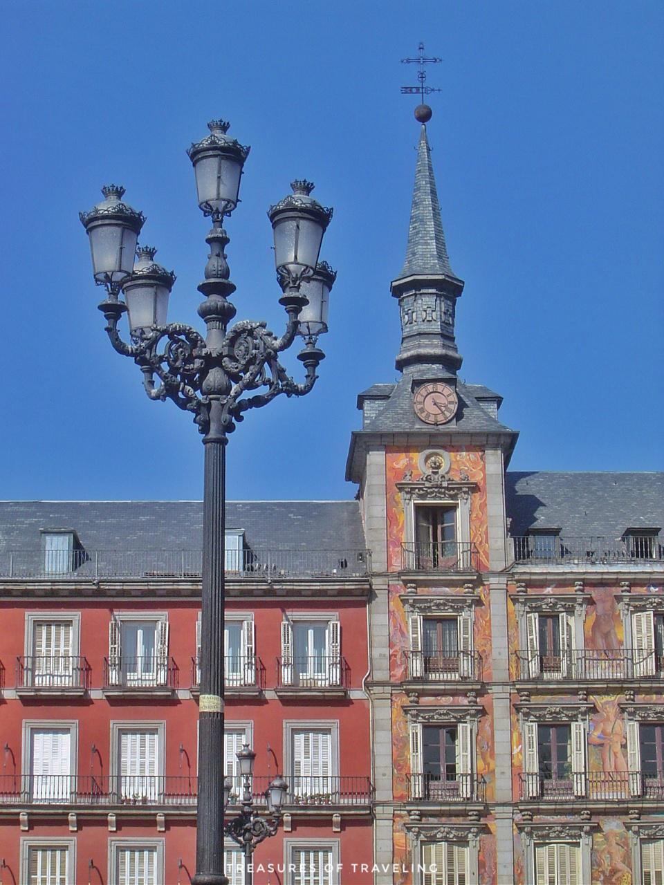 The light post and clock tower of Plaza Mayor. Madrid is the capital