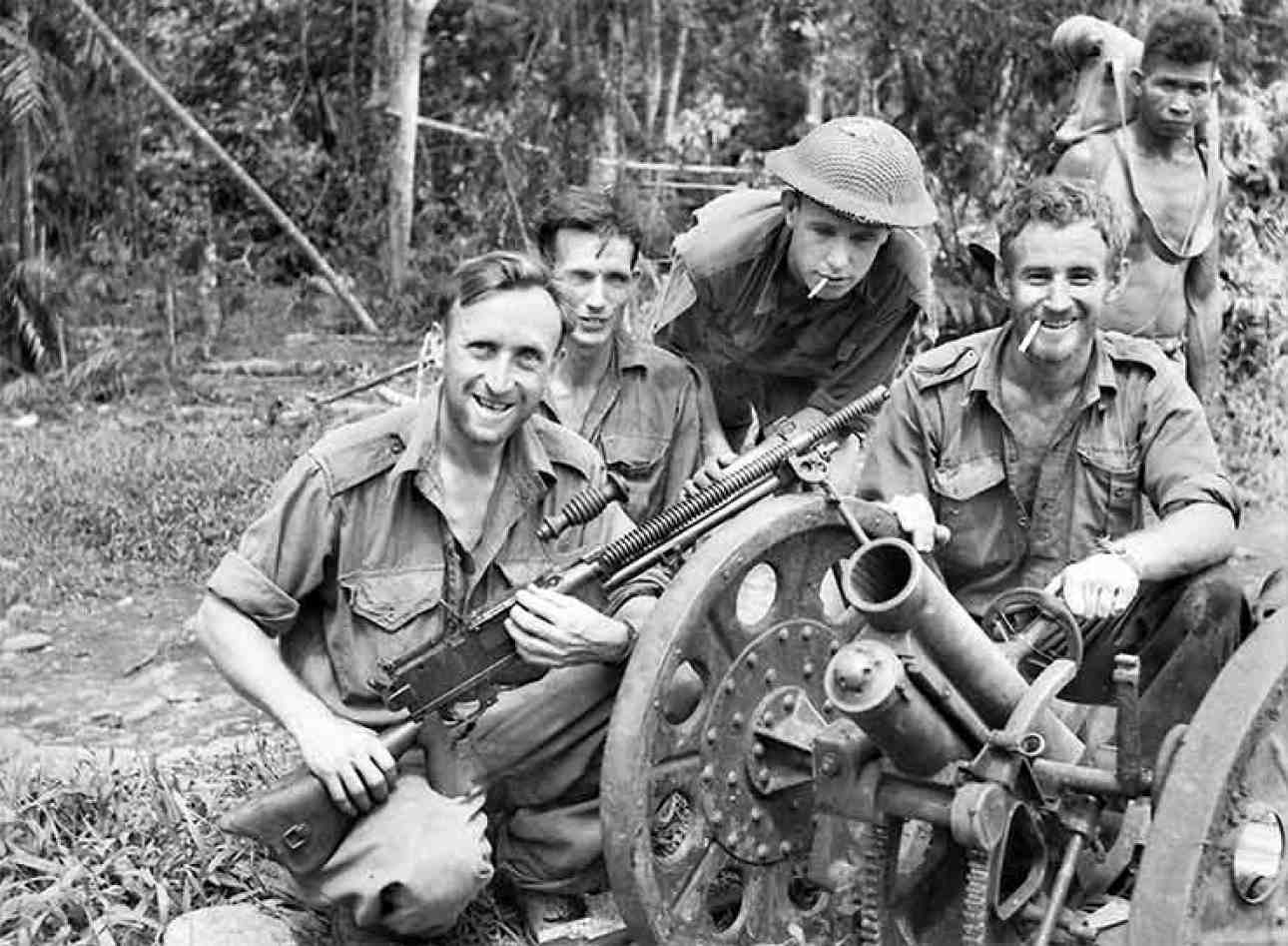 Australian soldiers pose with a captured Japanese 70mm Type 92 howitzer and Juki medium machine
