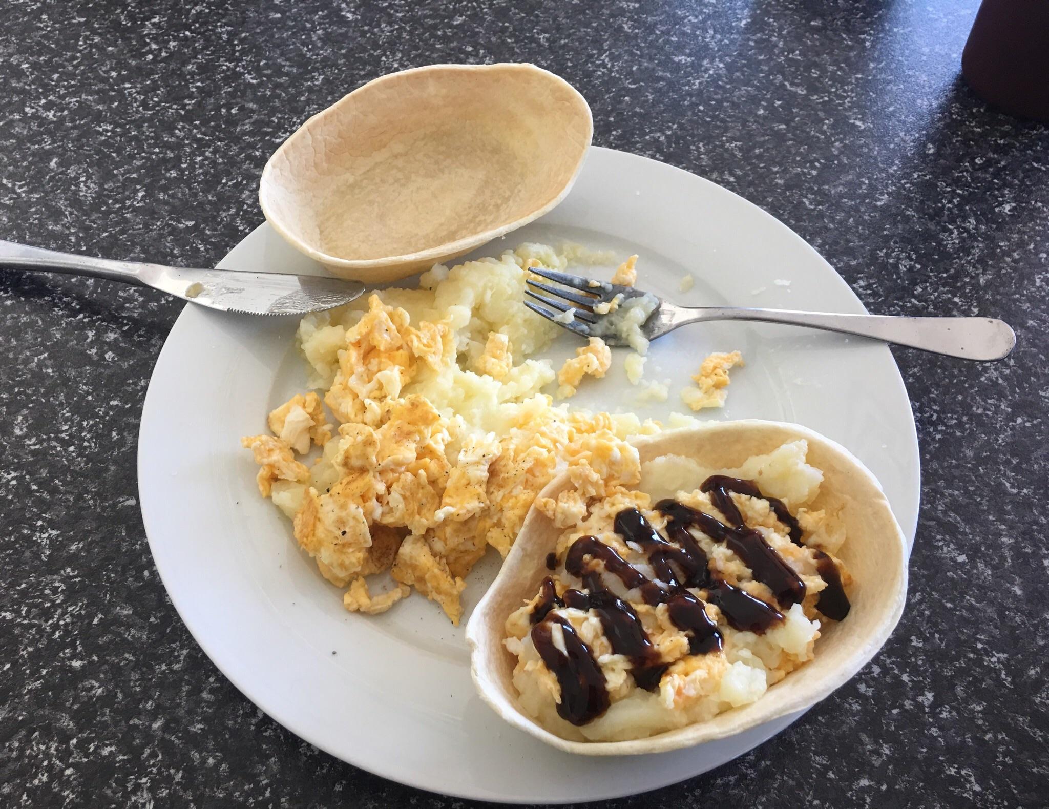 Mashed potato and scrambled eggs in a soft taco shell topped with
