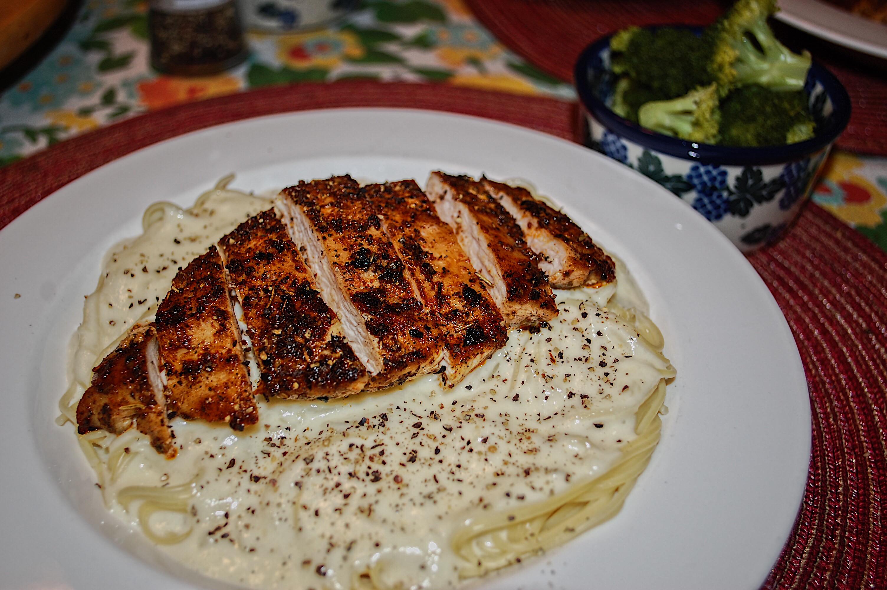 Chicken alfredo with angel hair pasta and a side of steamed broccoli
