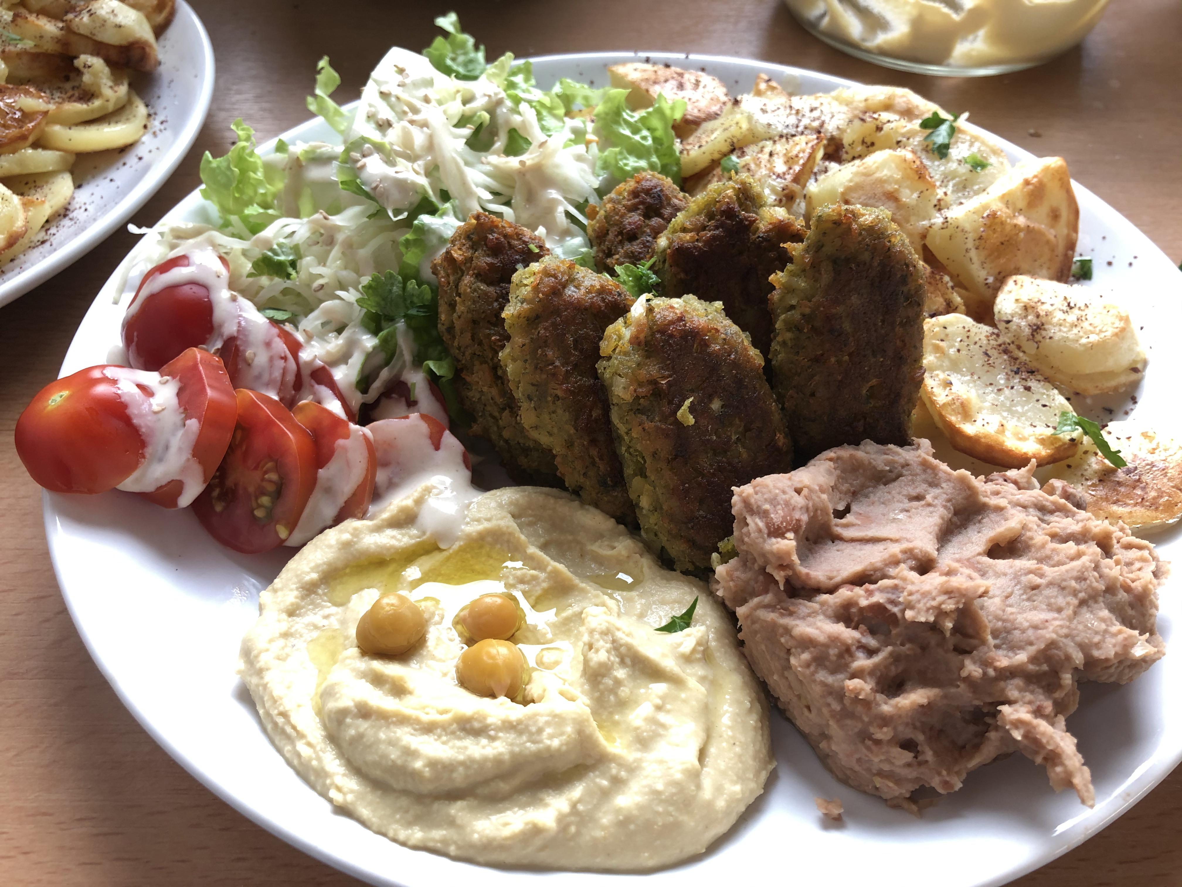 Vegan kebab, hummus, mashed beans, tahini sauce and potatoes with