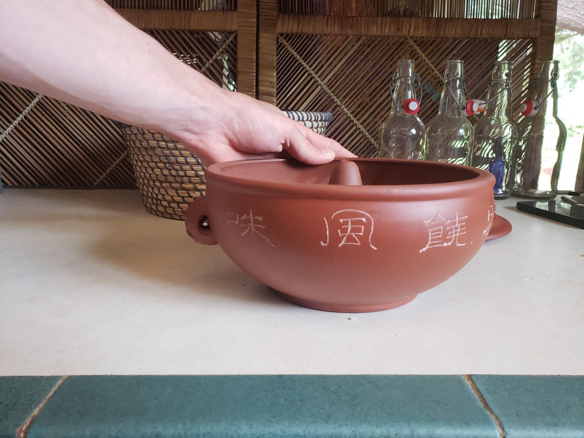 It is a clay bowl, two handles with holes through them, Inside of the