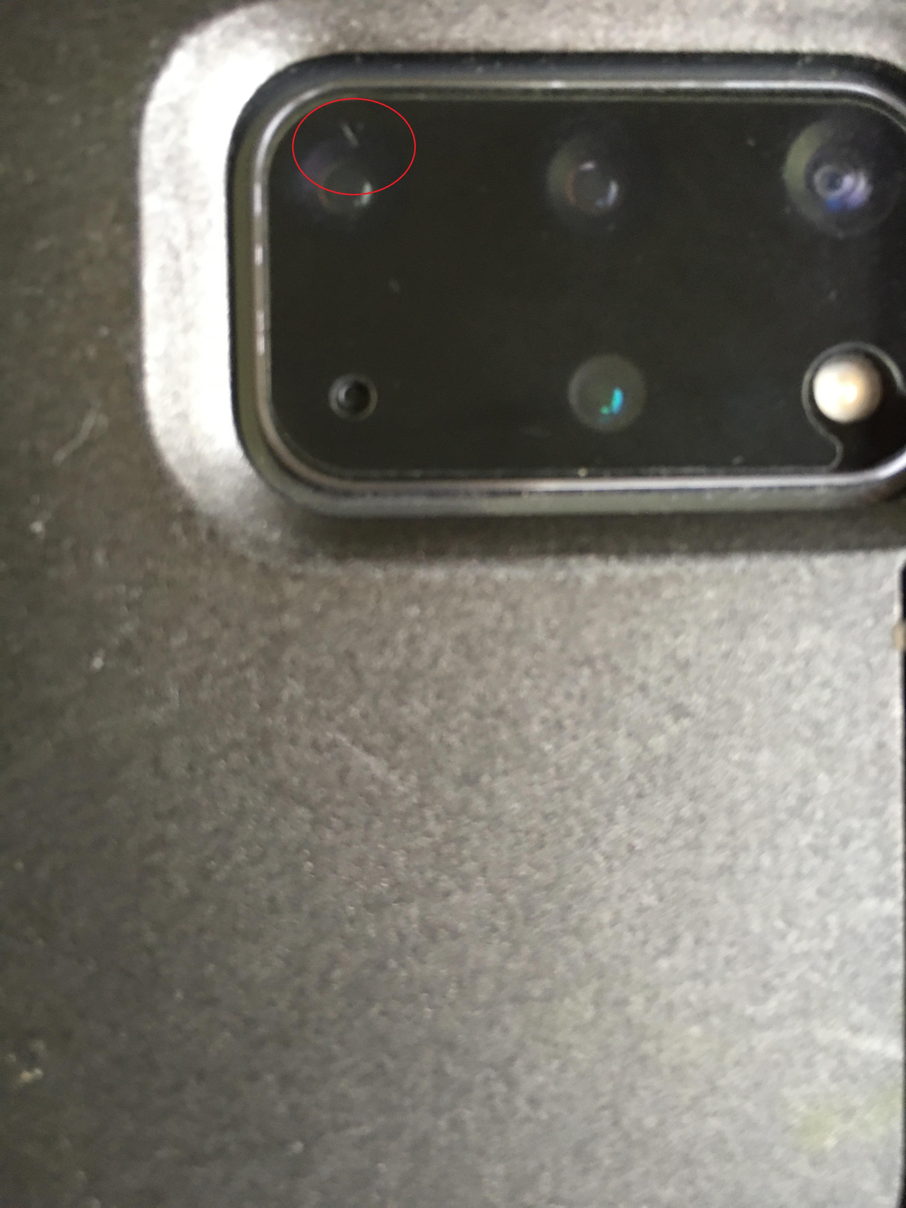 Dust(?) under the camera lens. Anyone knows what this is or have