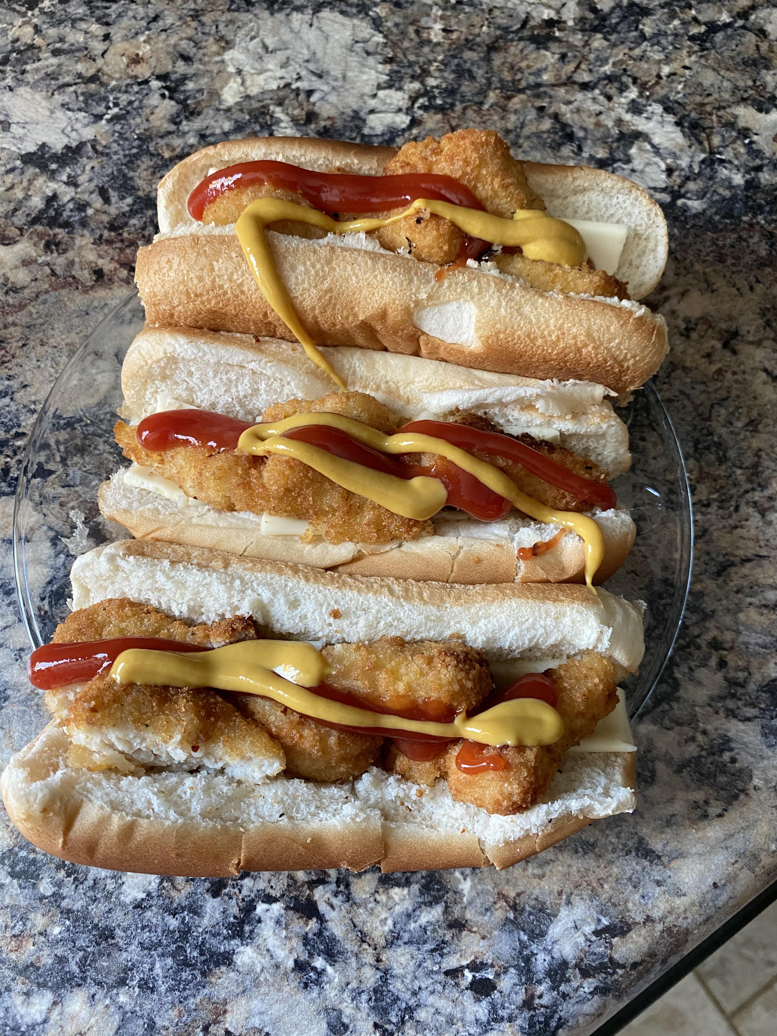 chicken nuggets cut diagonally and placed into hotdog buns topped with