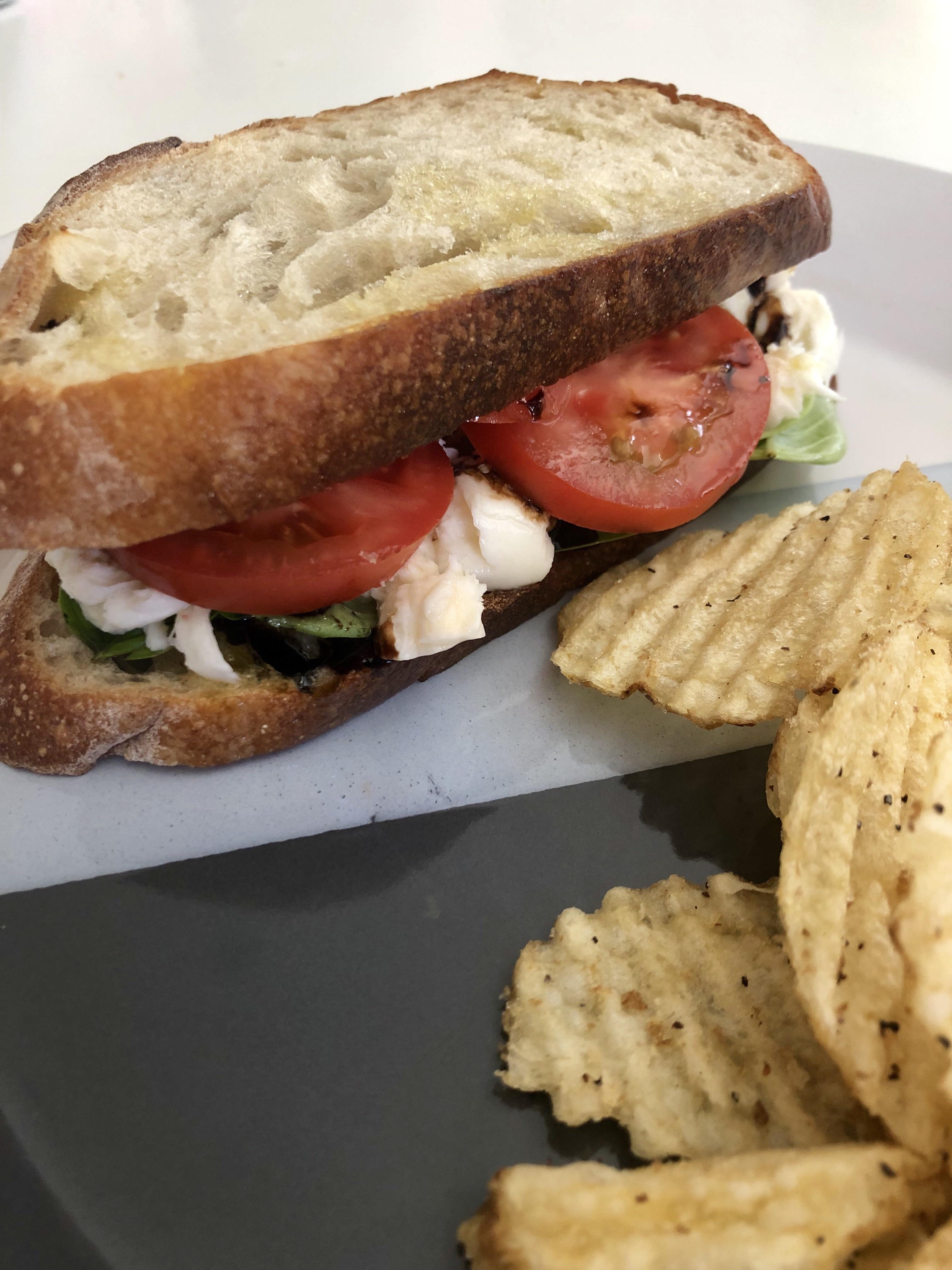 Sourdough bread, olive oil, basil, mozzarella cheese, tomato, and a balsamic glaze drizzle. r