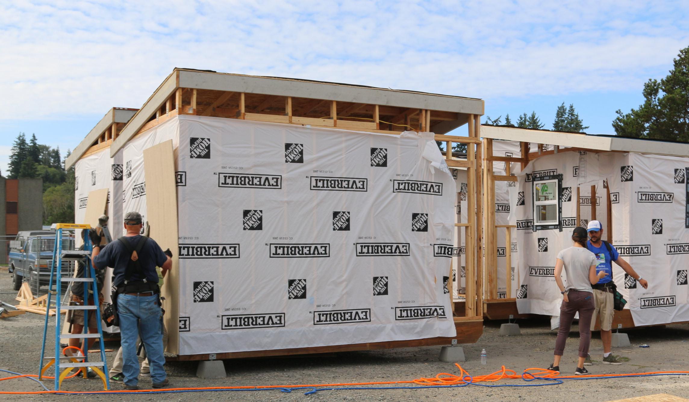 Volunteers building tiny homes for the homeless by the treatment plant