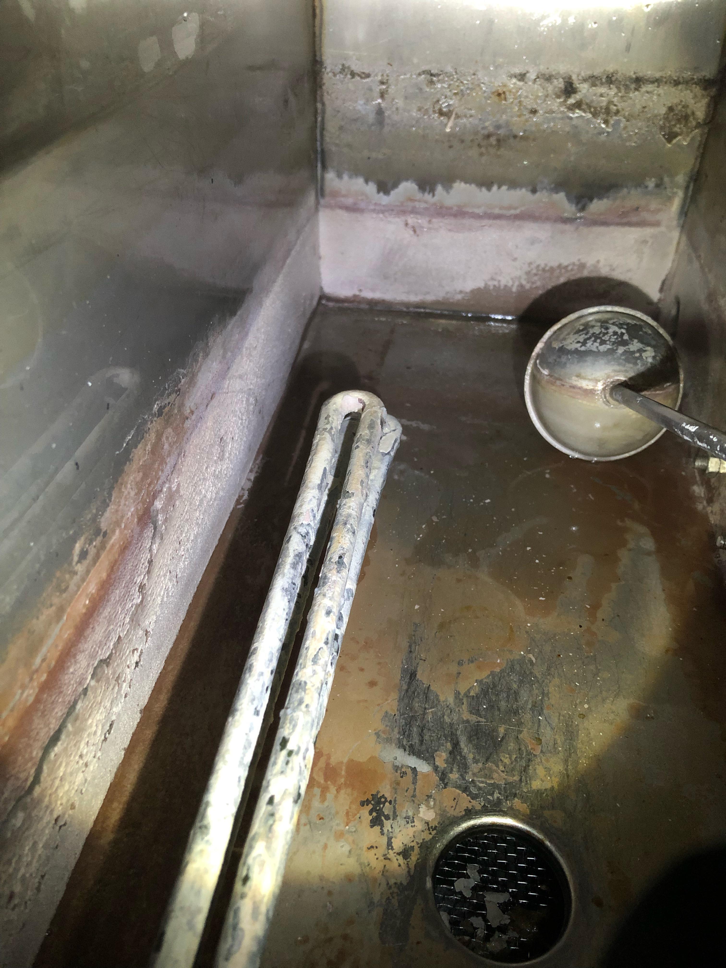 How to clean this residue in the water basin of a Commerical glassware