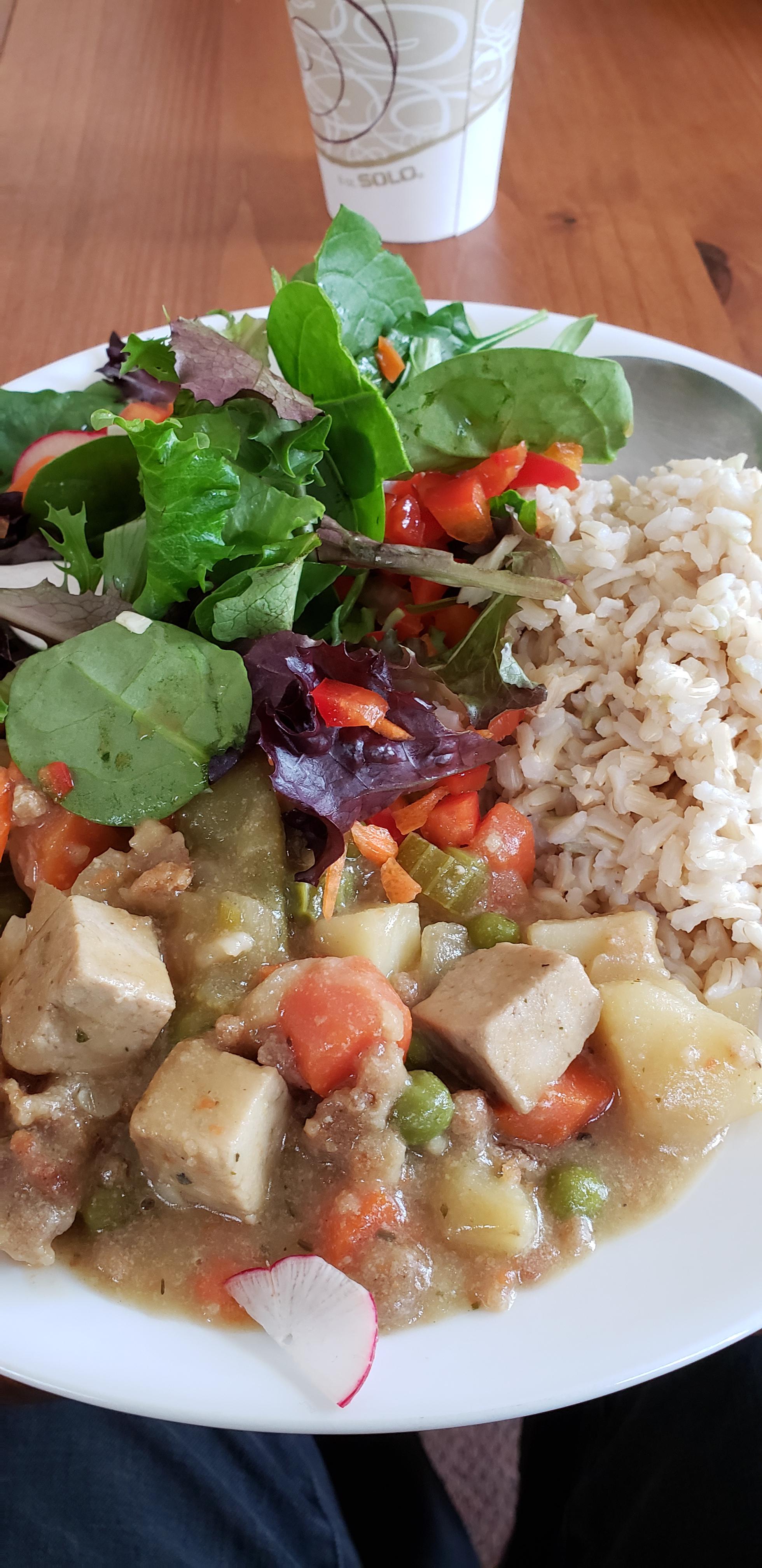 Vegetable tofu casserole with rice and salad. Served at the Sant Bani