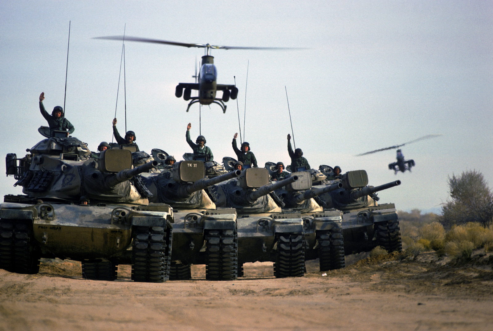 US Army soldiers give hand signals from M60 main battle tanks during a