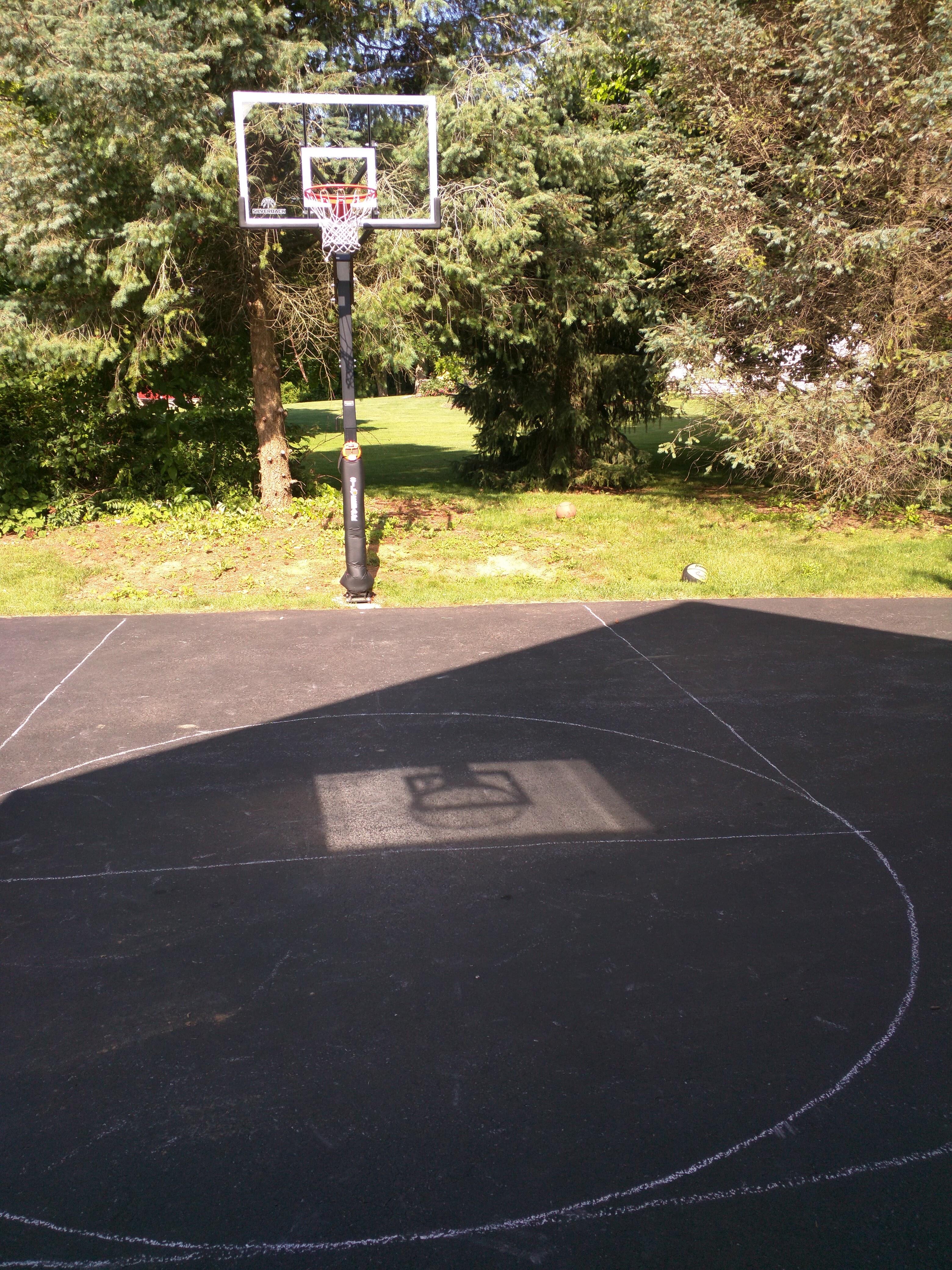 Reflection off the basketball backboard creates a "hole" in the house's shadow r/mildlyinteresting