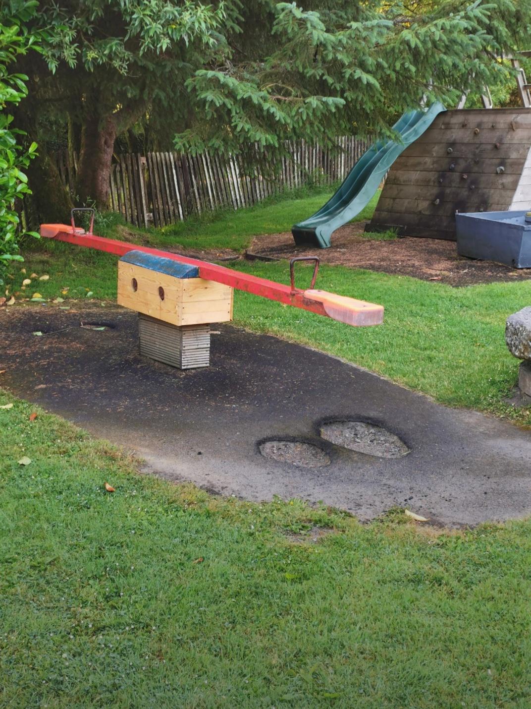 A seesaw (teetertotter) in my local playground where thousands of little feet have worn through
