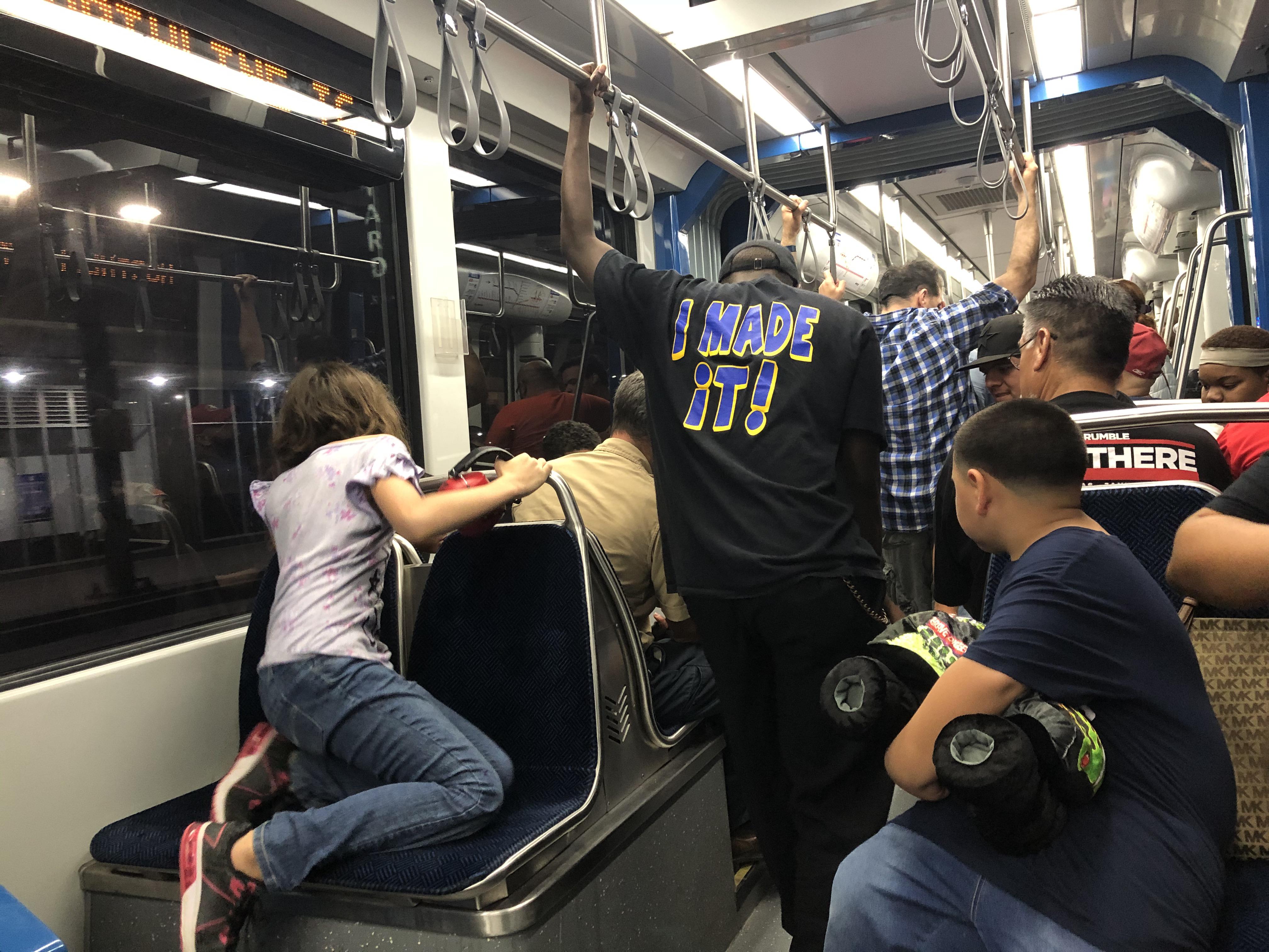 Crowding around a cellphone that is streaming the Astros game on Metro
