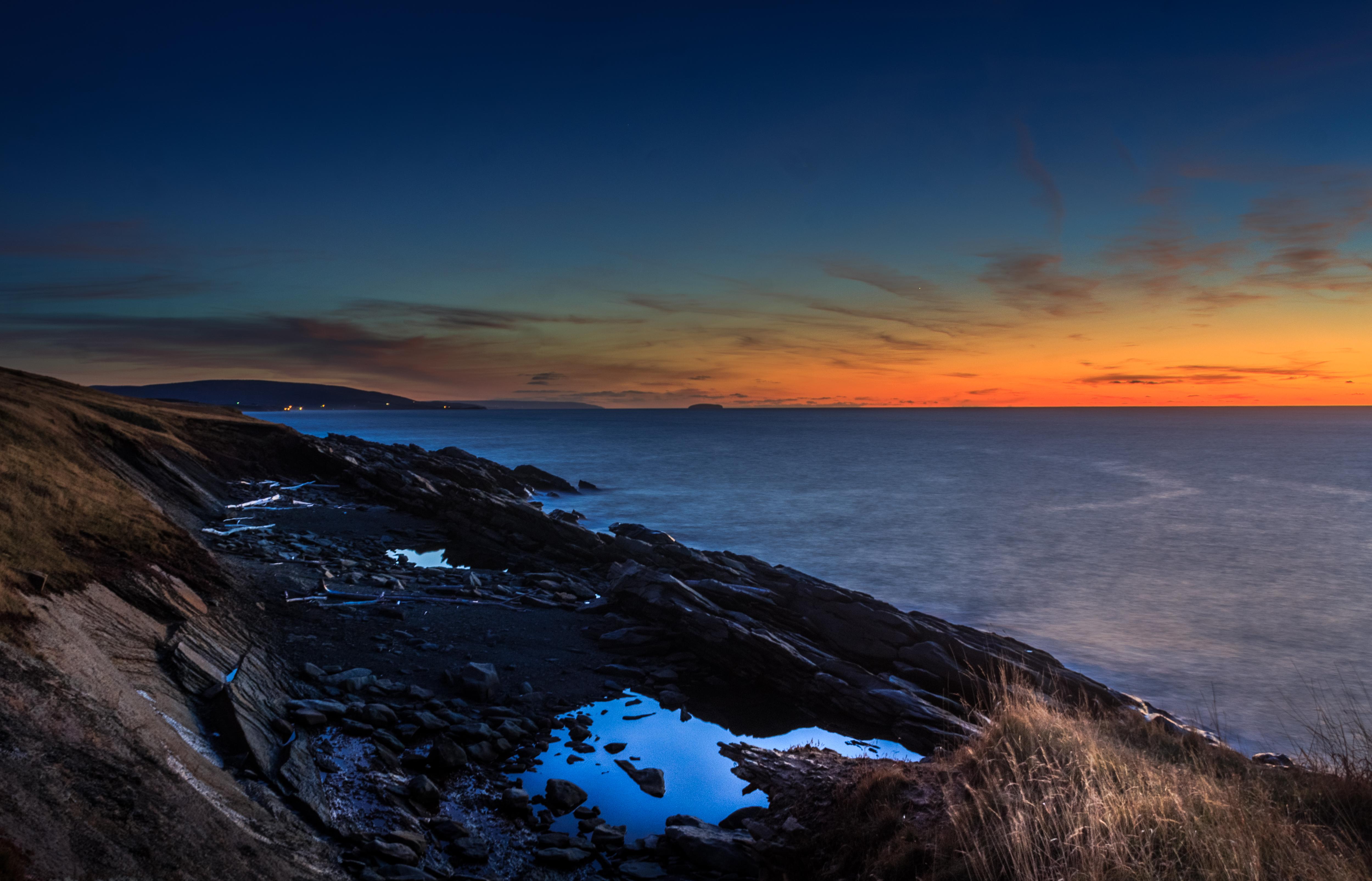 the rugged coastline of Cape Breton, Nova Scotia, just after sunset