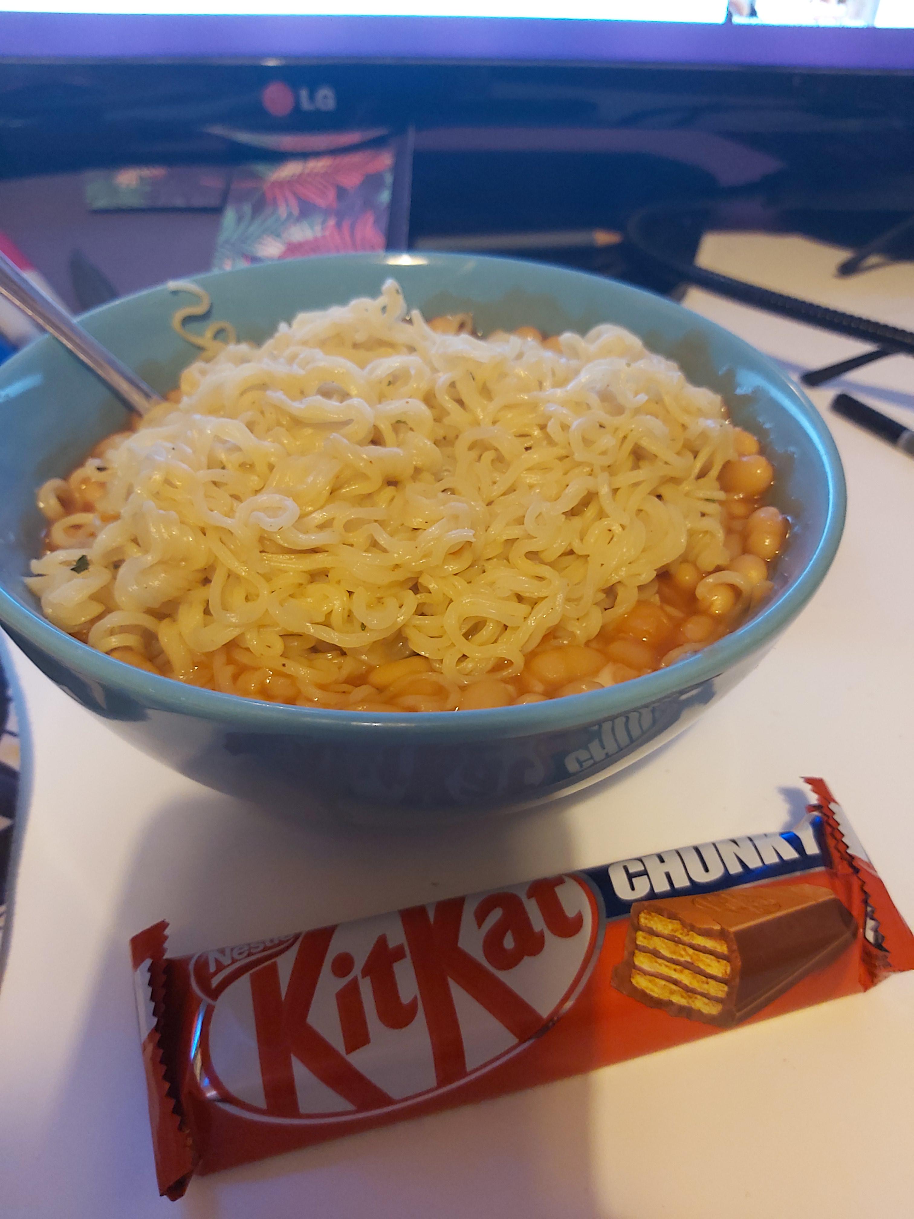 Instant noodles bathed in baked beans and mixed with mozzarella, with a