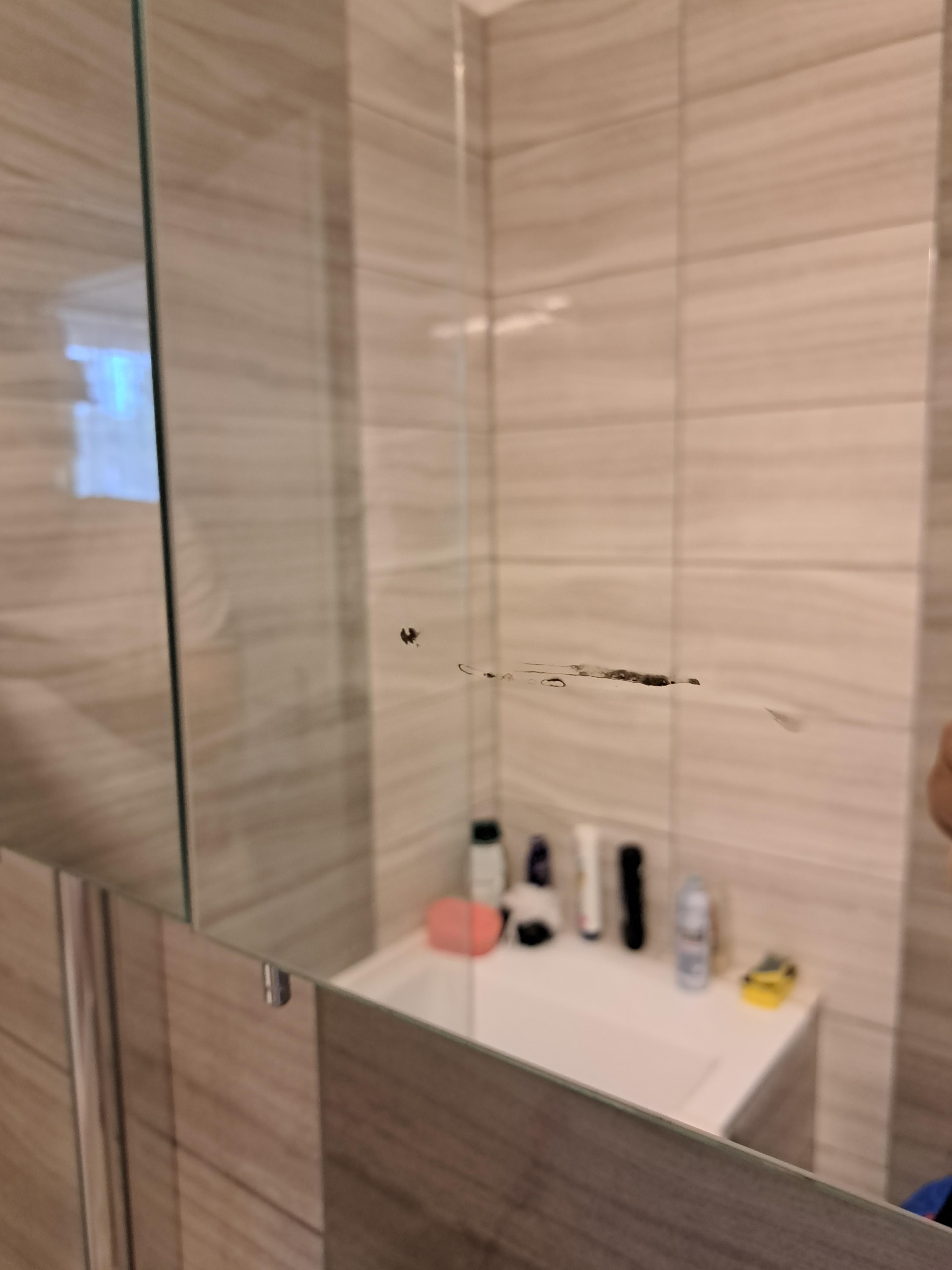 We were cleaning the bathroom and found this stain on the mirror, it wont come off, looks like