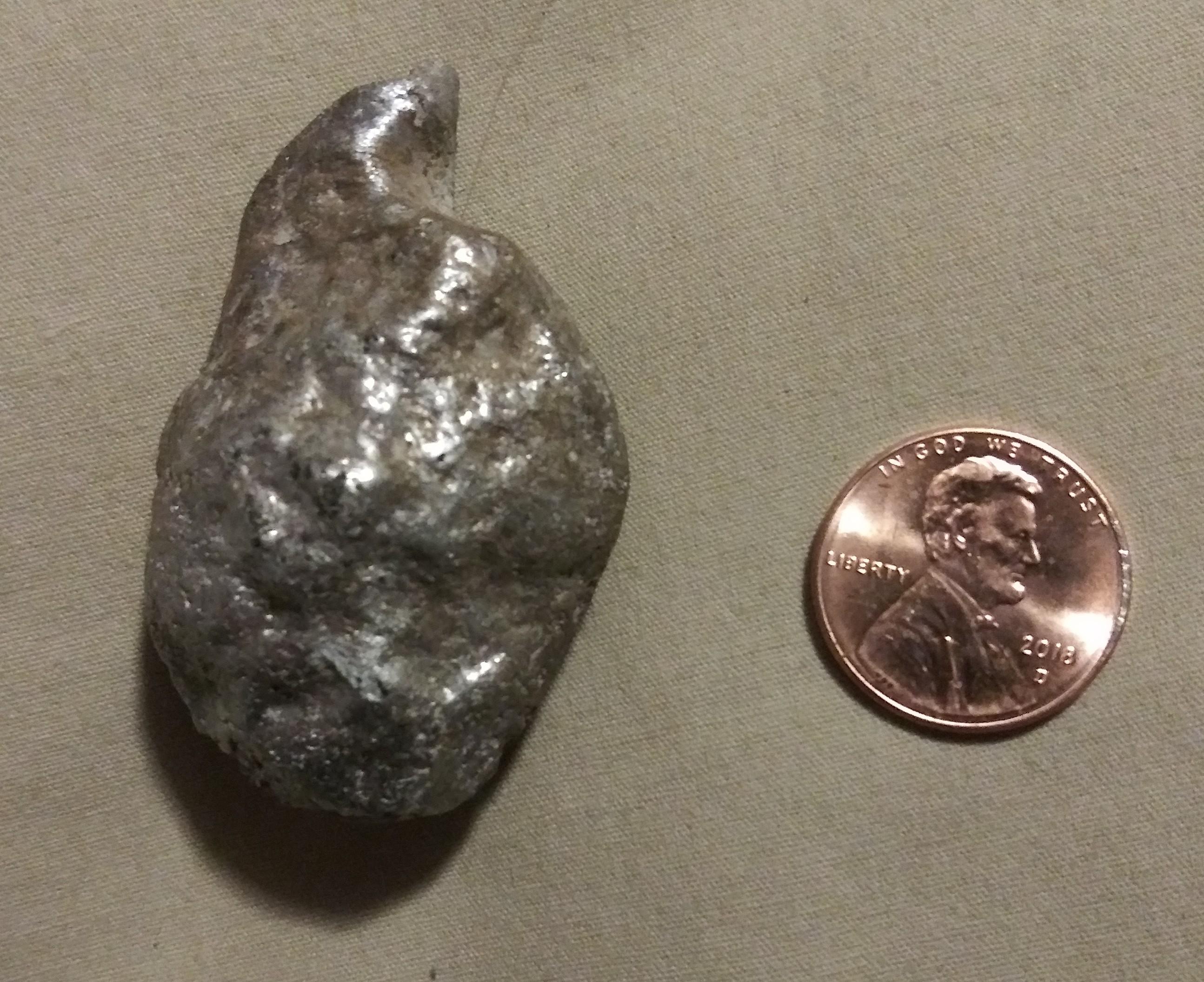Shiny silver "rock" found surounded by ash next to my car one morning