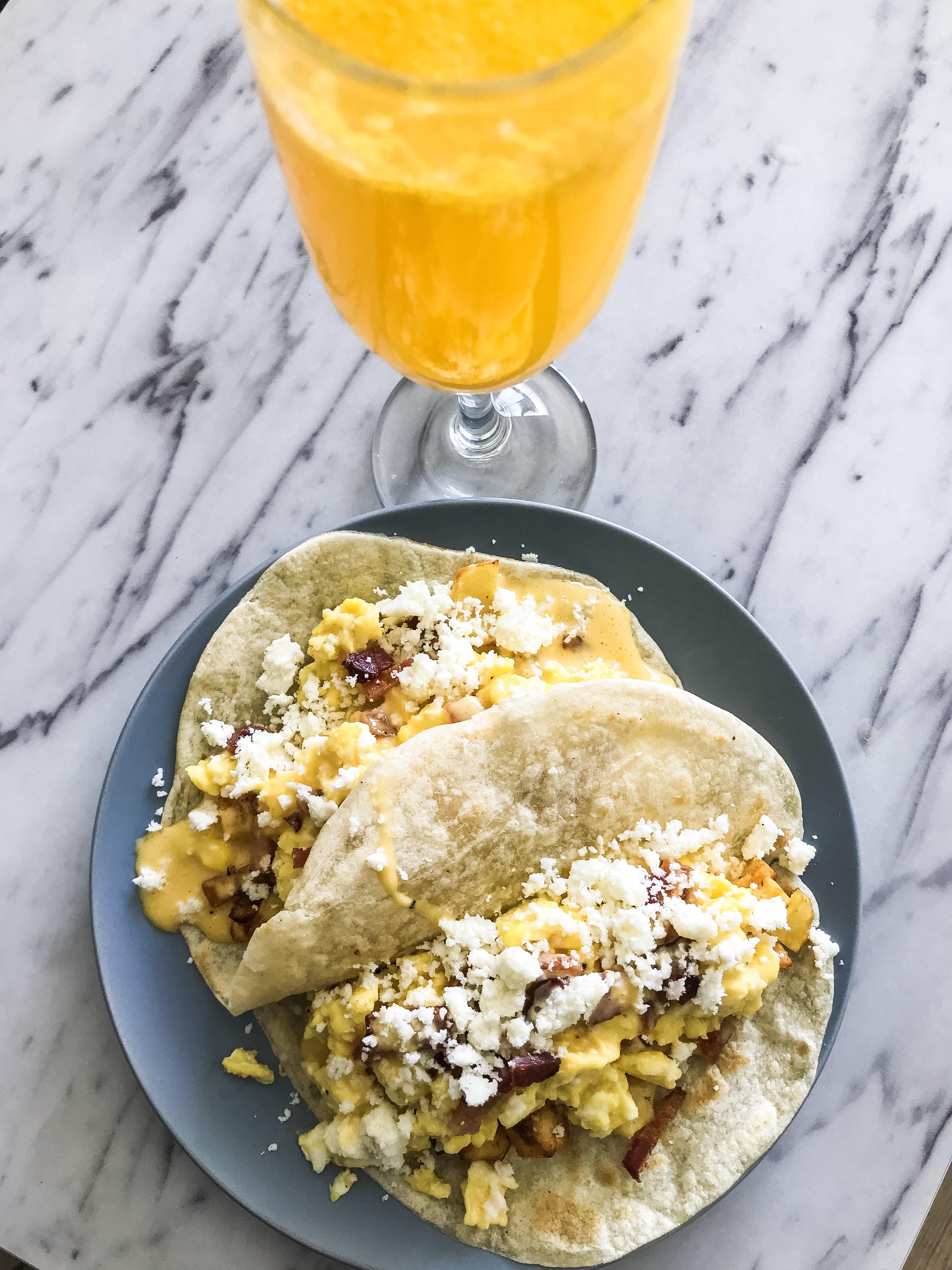Breakfast Tacos with egg, bacon, potatoes, pickled onions, hollandaise sauce and cotija cheese