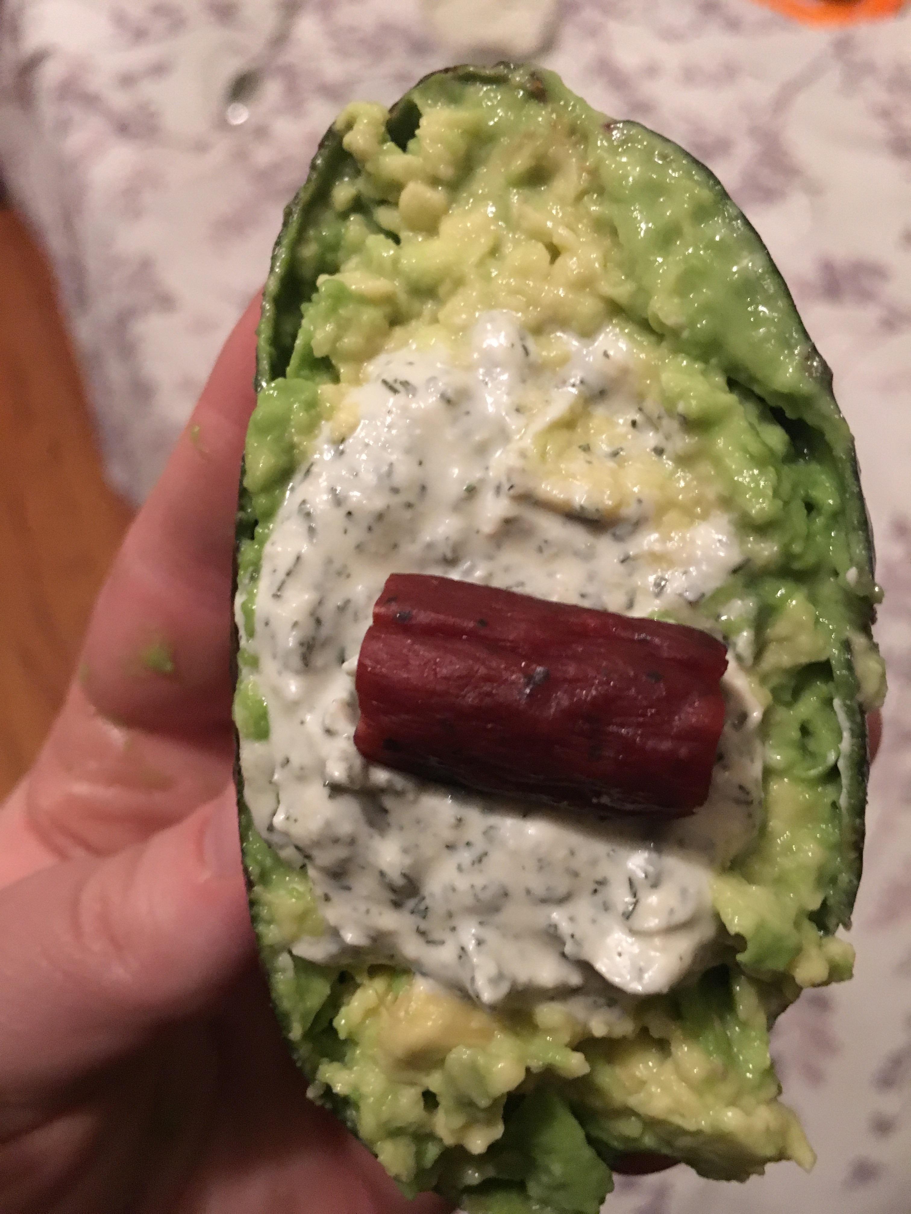 Avocado mash filled with dill dip and topped with turkey sausage. r