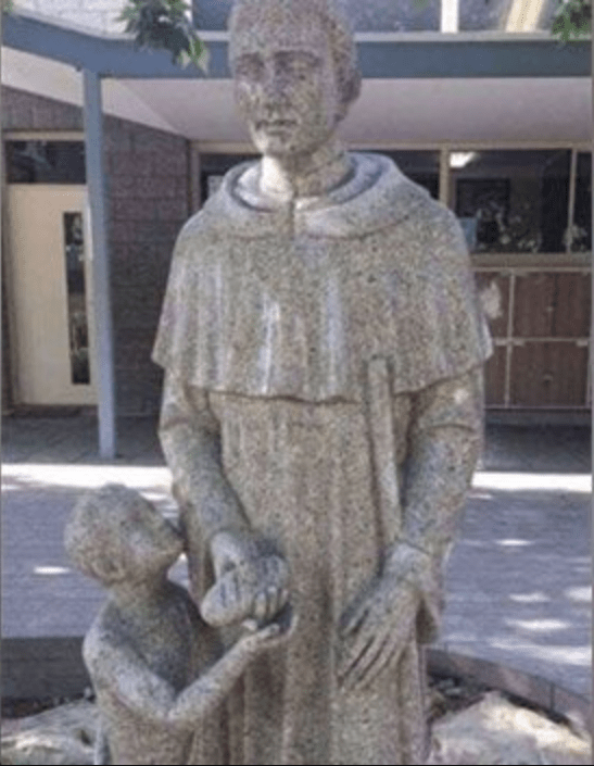 This statue outside an Australian Catholic School showing a priest giving 'bread' to a kid r/pics