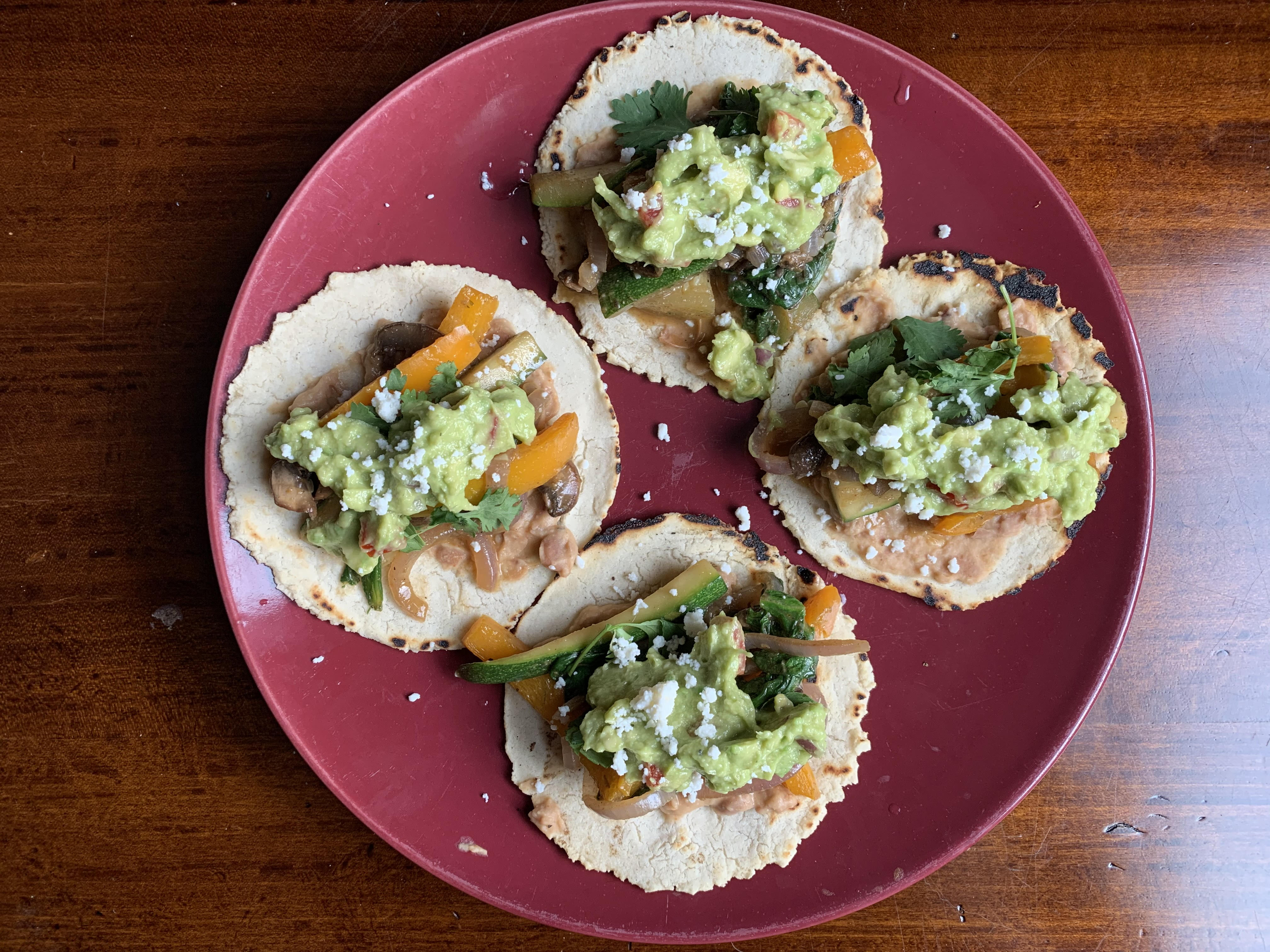Homemade corn tortillas with mixed vegetables, pinto beans, and