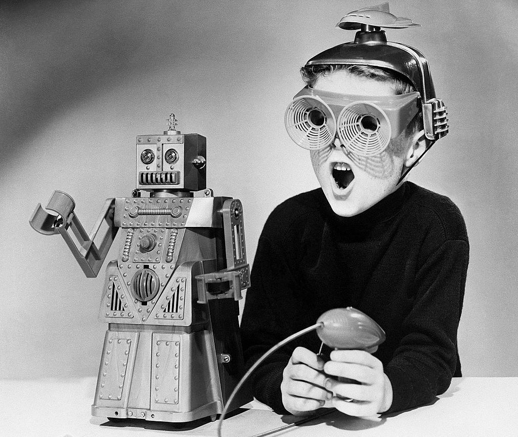 A boy wearing a futuristic space helmet and goggles demonstrates the