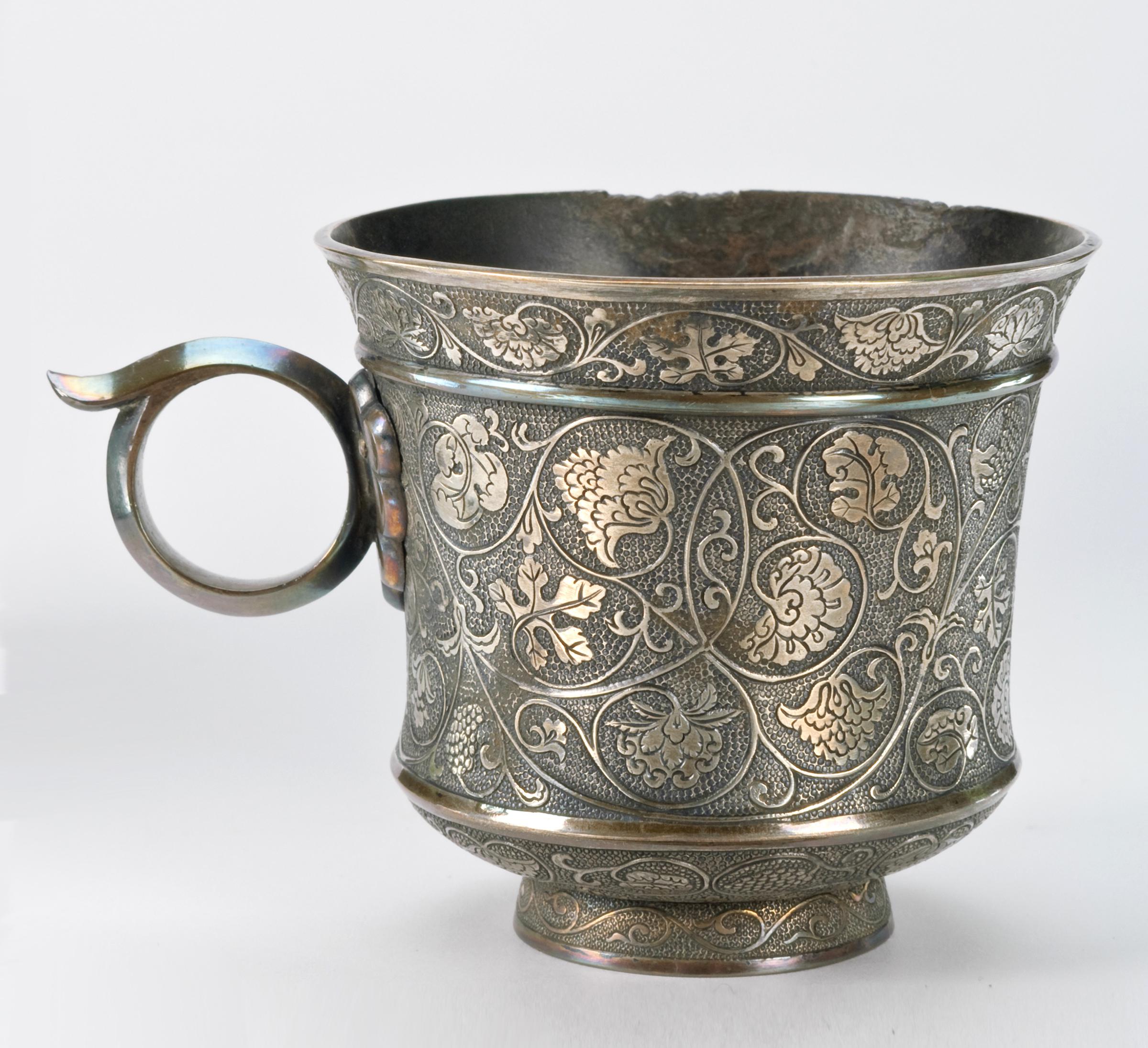 Silver cup with ring handle and floral designs. China, Tang Dynasty