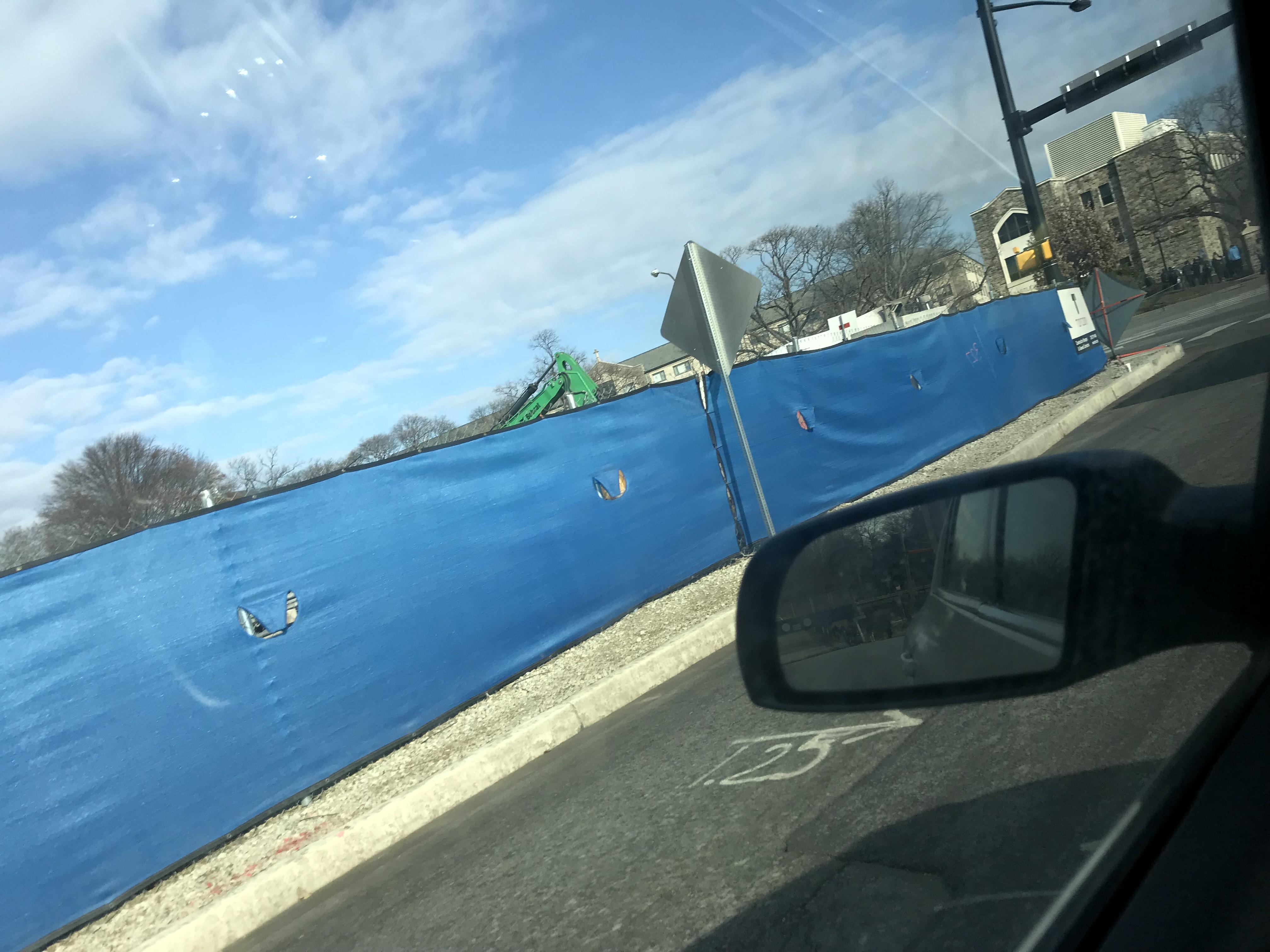 What are these holes in the side of the tarp at a construction site
