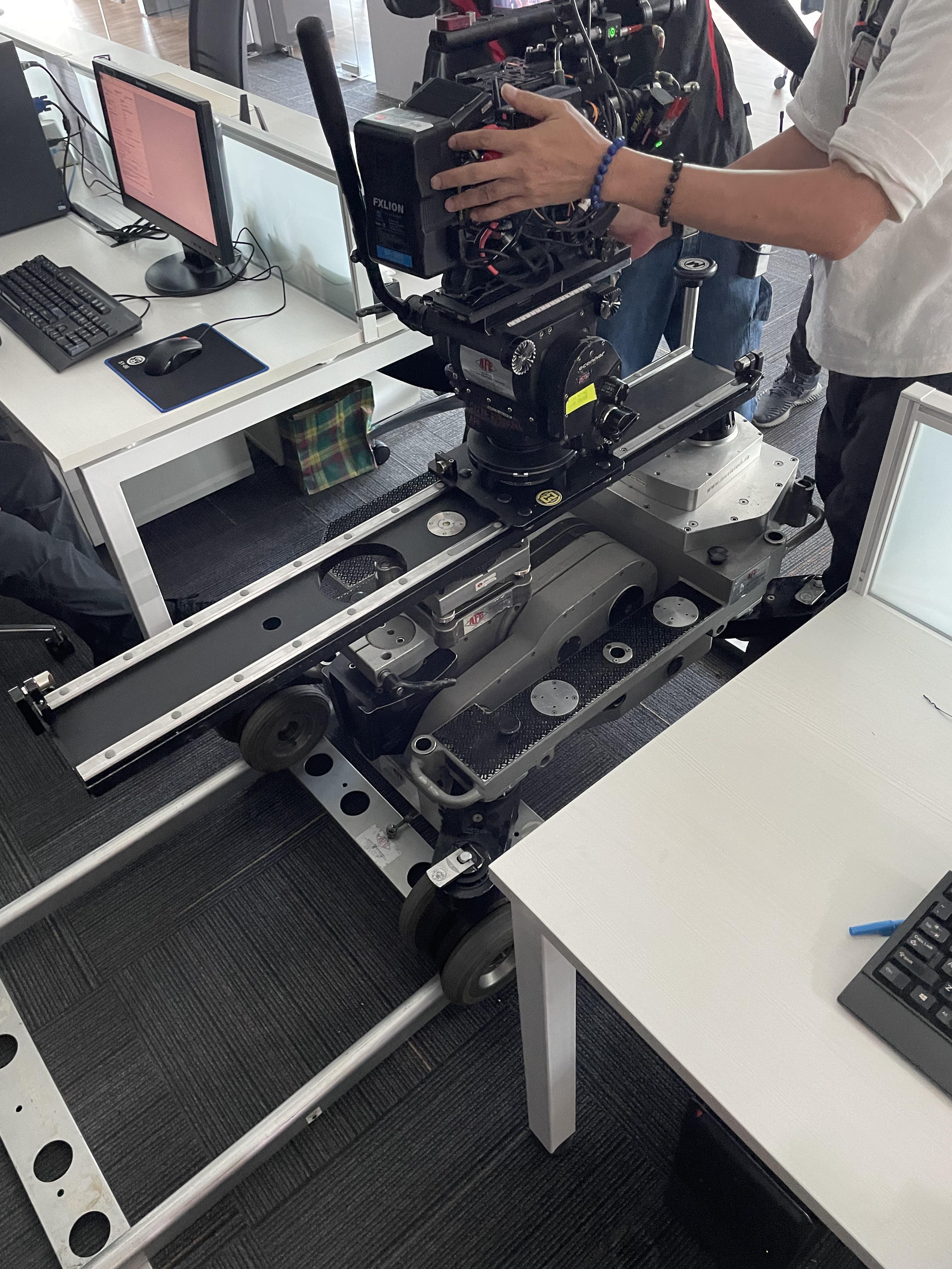 A cinema camera slider attached to a camera dolly in the same