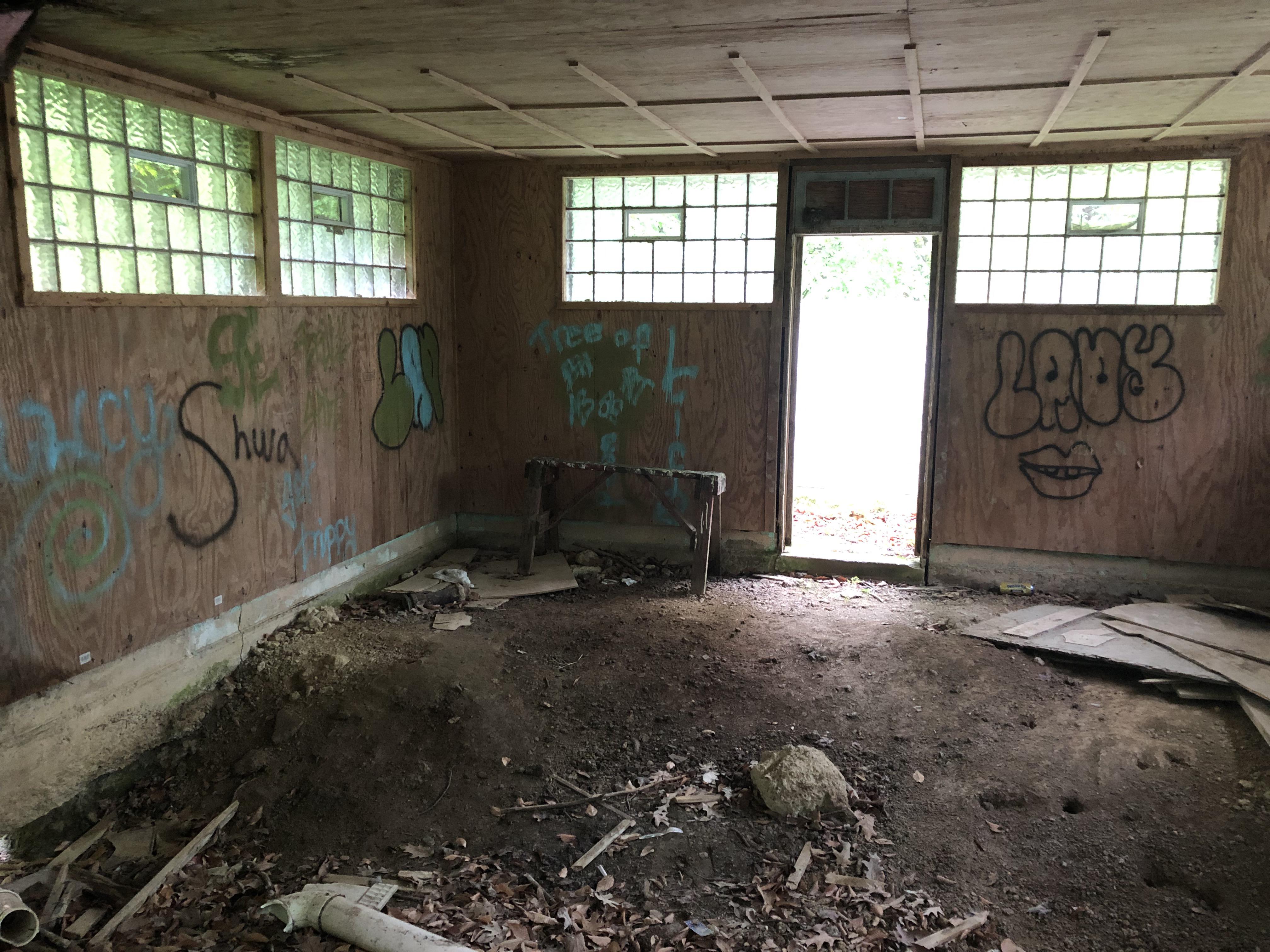 Abandoned public restroom in a forest park turned hangout spot. r