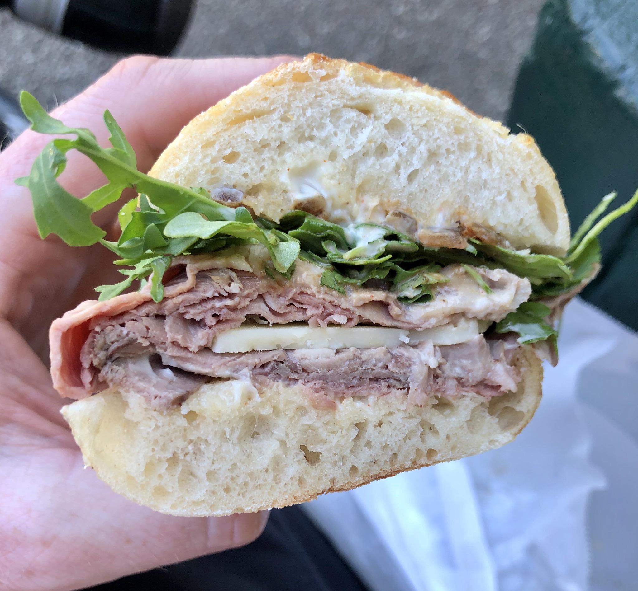 Roast beef, cheddar, arugula, carmelized onion, and horseradish cream on a baguette r