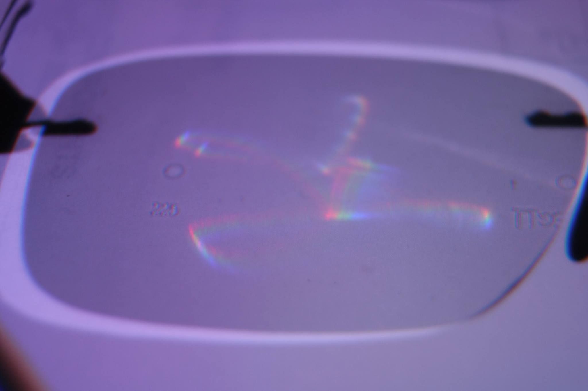 Something embossed on my eyeglass lenses (writing to the far left of