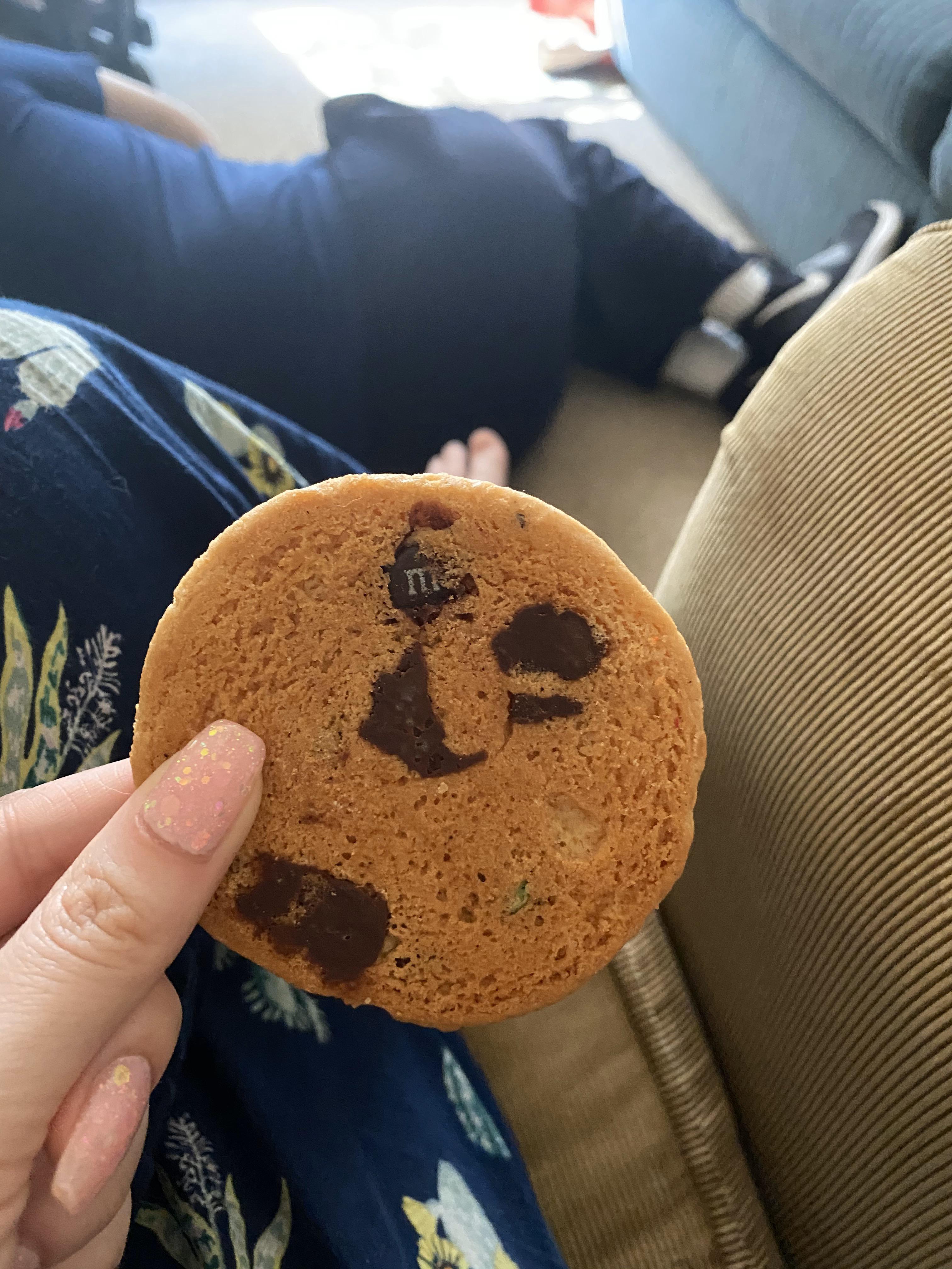 The "M" of an M&M showing through the surface of my friend's cookie r