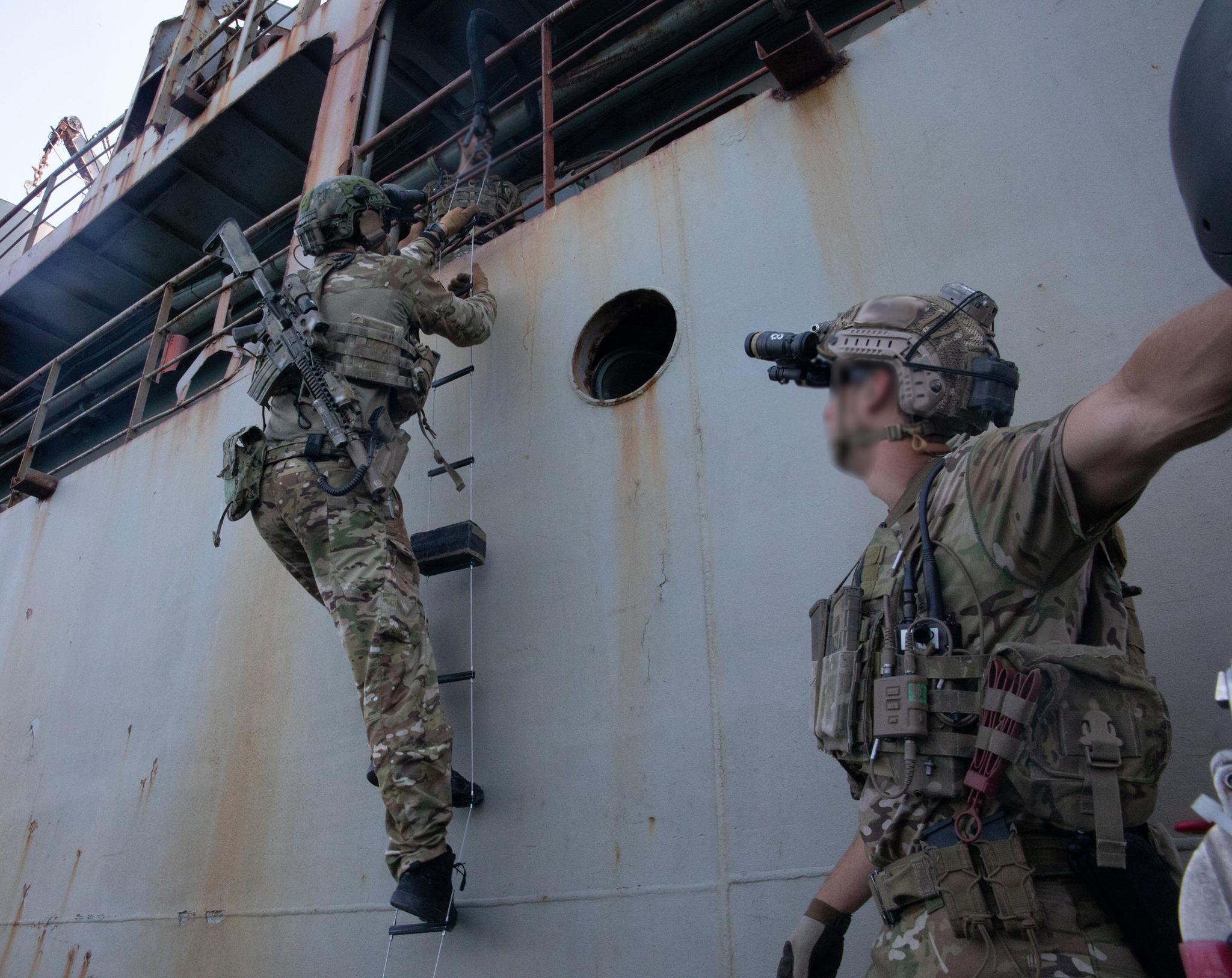 U.S. Naval Special Warfare Operators climb aboard a simulated enemy