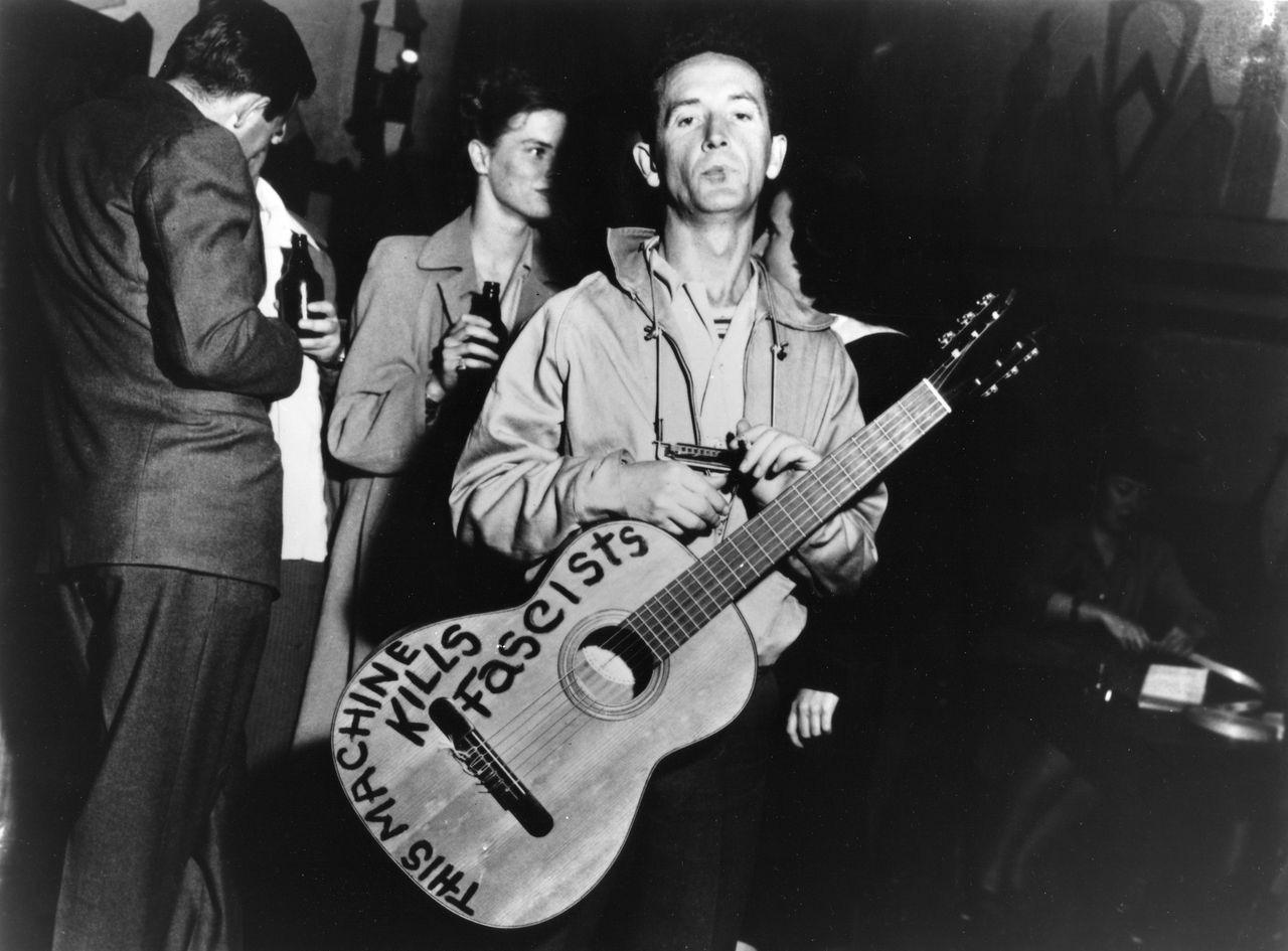 Woody Guthrie and his famous guitar, 1941 r/OldSchoolCool