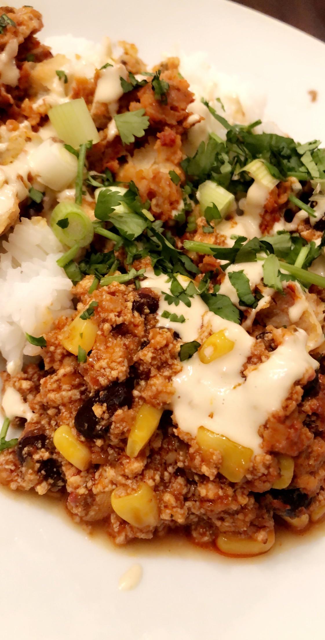 Sofritas enchilada over white rice with a cashew cheese drizzle r