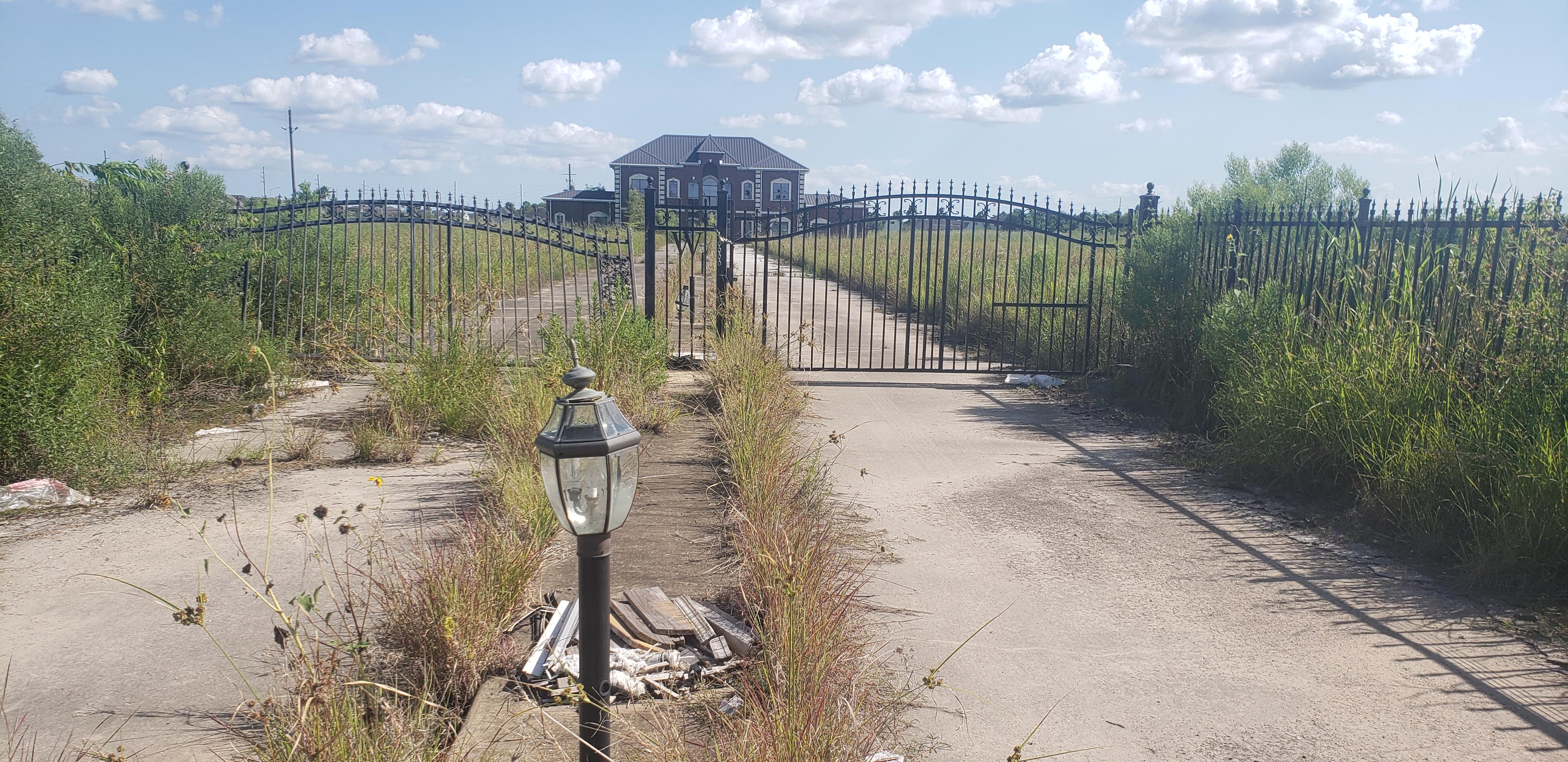 The broken gate of an abandoned mansion in Pearland, TX. Kids at my