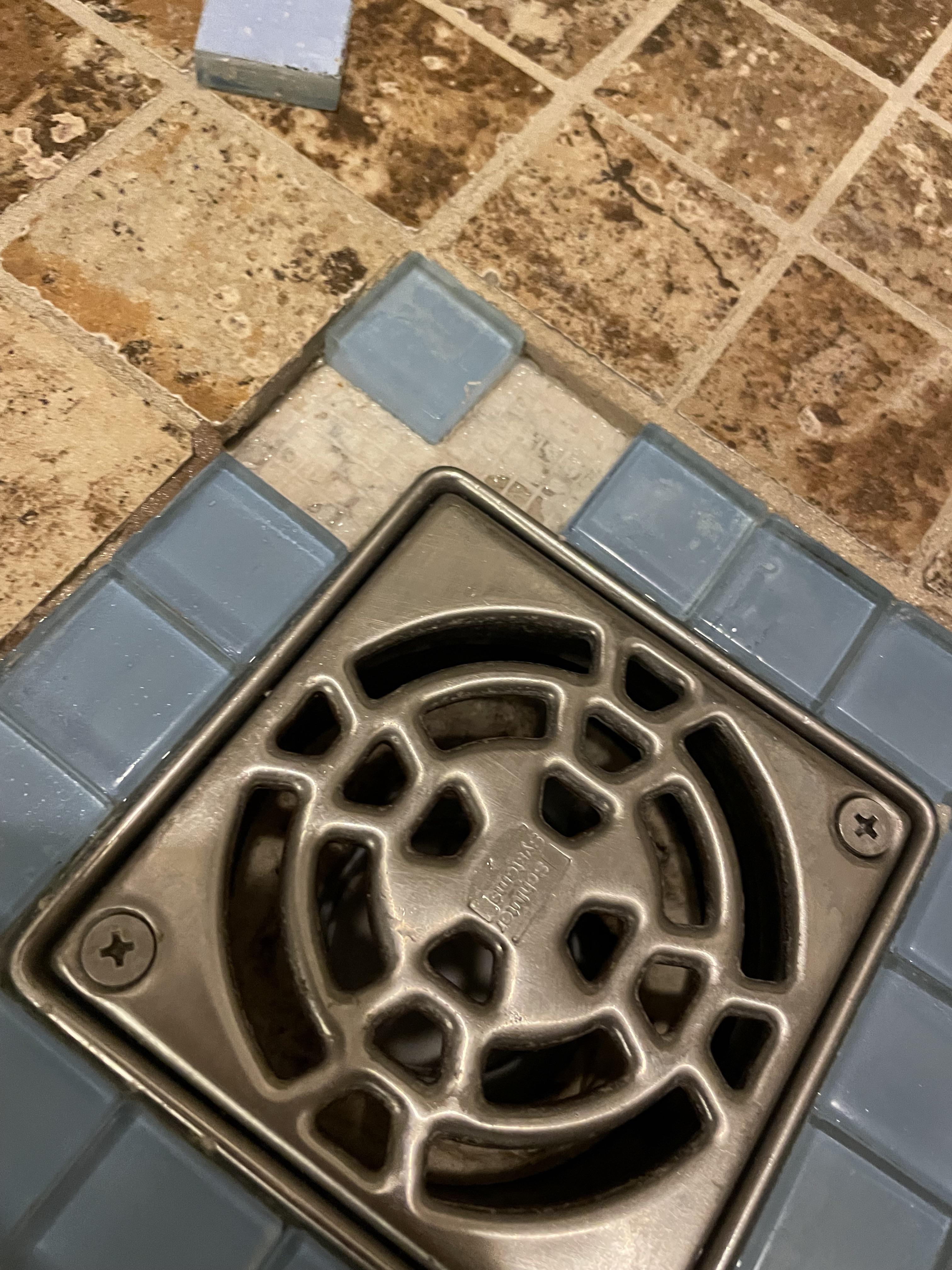 What sort of glue should I use to glue the mosaic pieces back near the shower drain? r/Tile