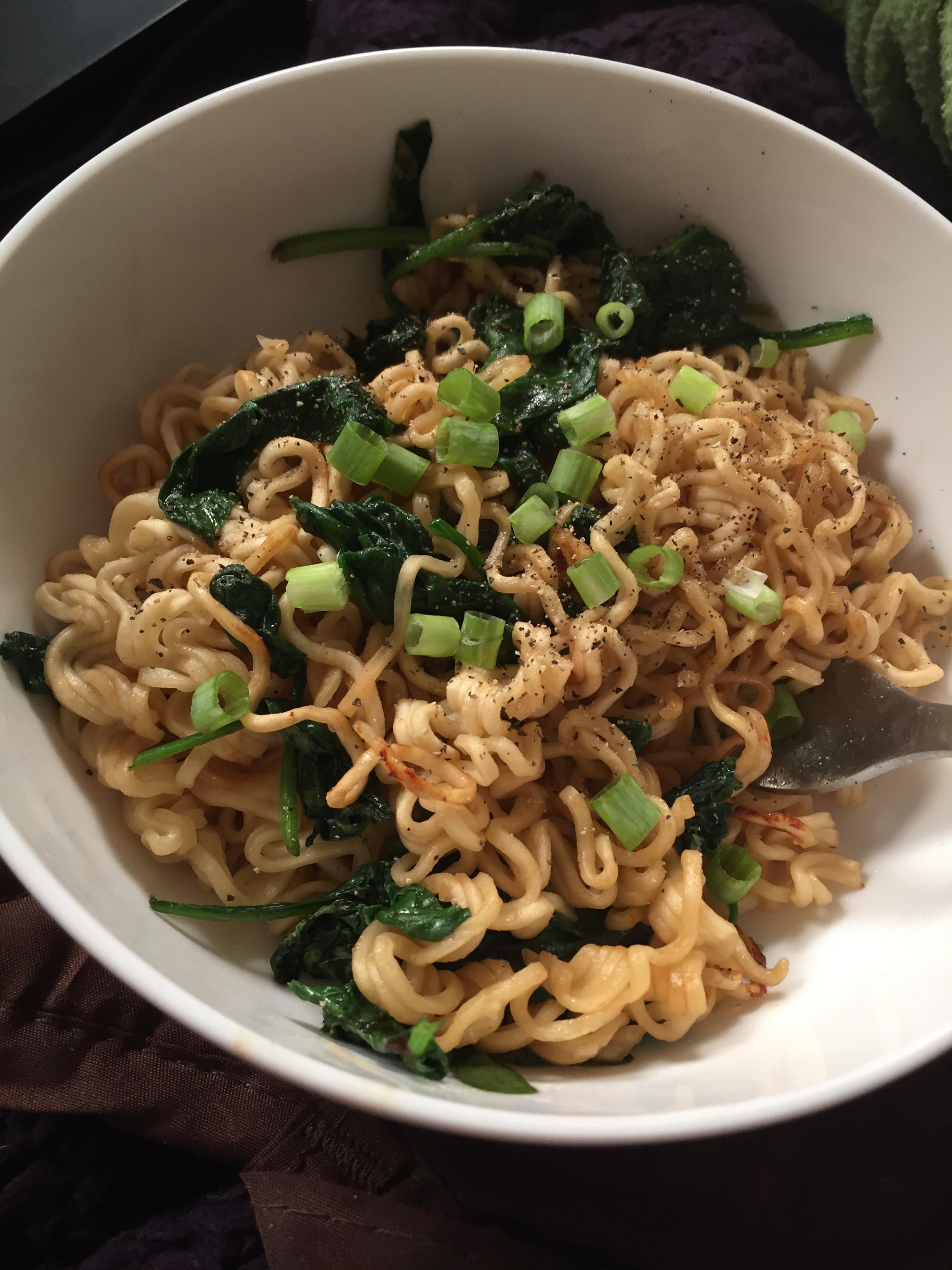 Oriental Top ramen stir fried with spinach and garnished with green