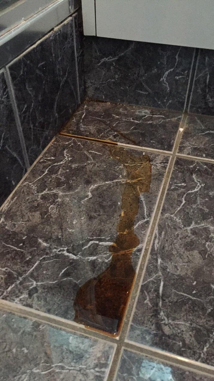 Strange brown oozing liquid coming out a crack between the shower and
