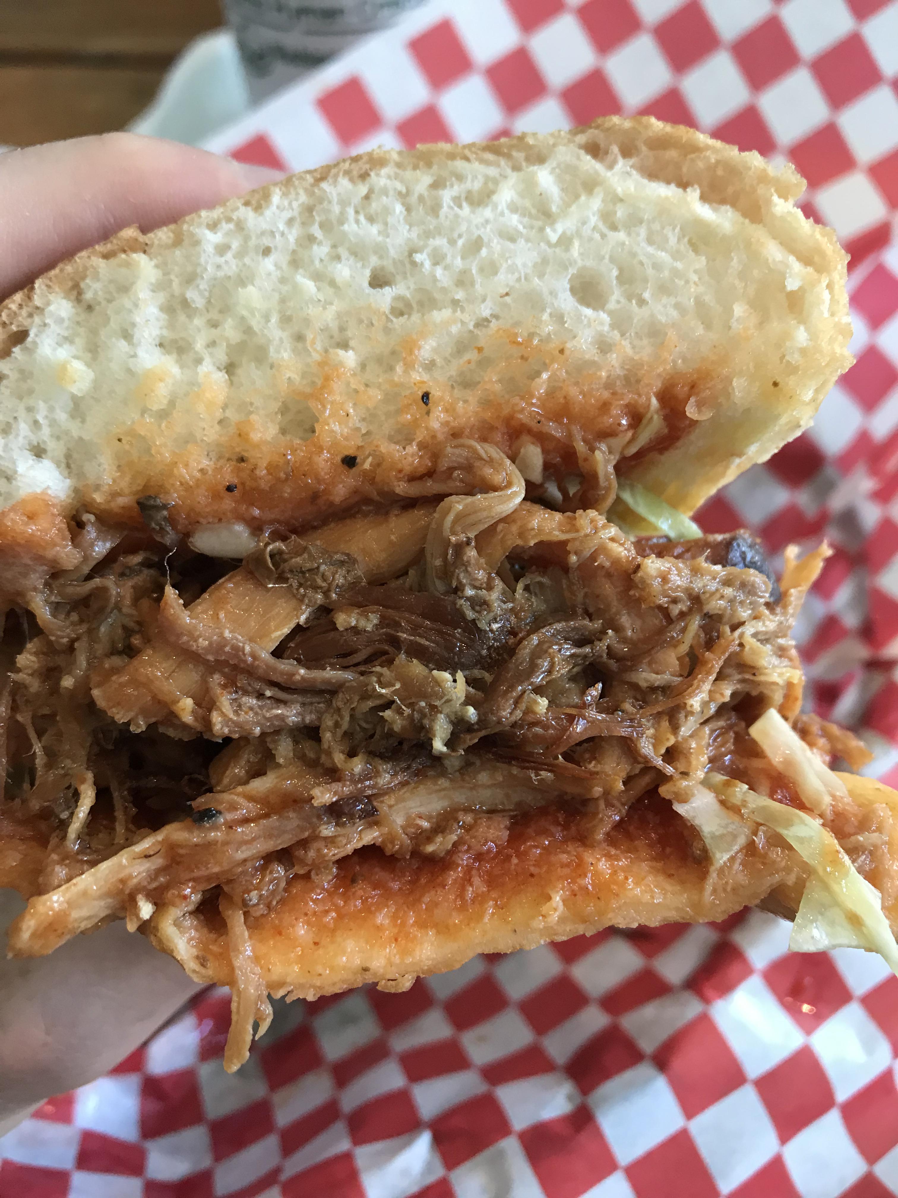 Kalua pulled pork, guava bbq sauce, and slaw on a french roll r