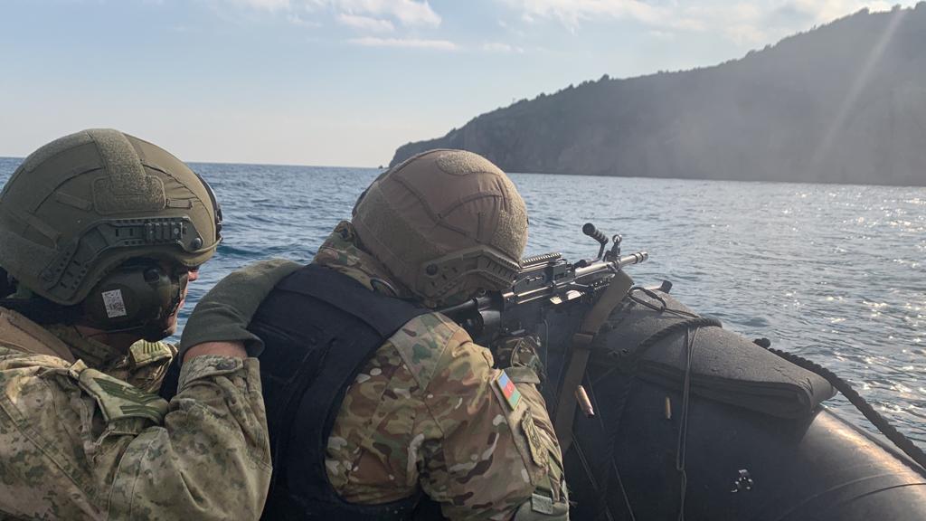 An Azerbaijani amphibious commando fires M249 LMG from a combat rubber