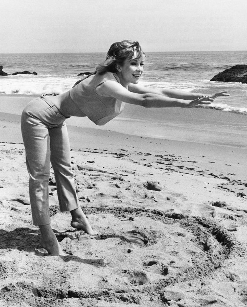 1963 Barbara Eden demonstrating how she stretched on the beach to stay