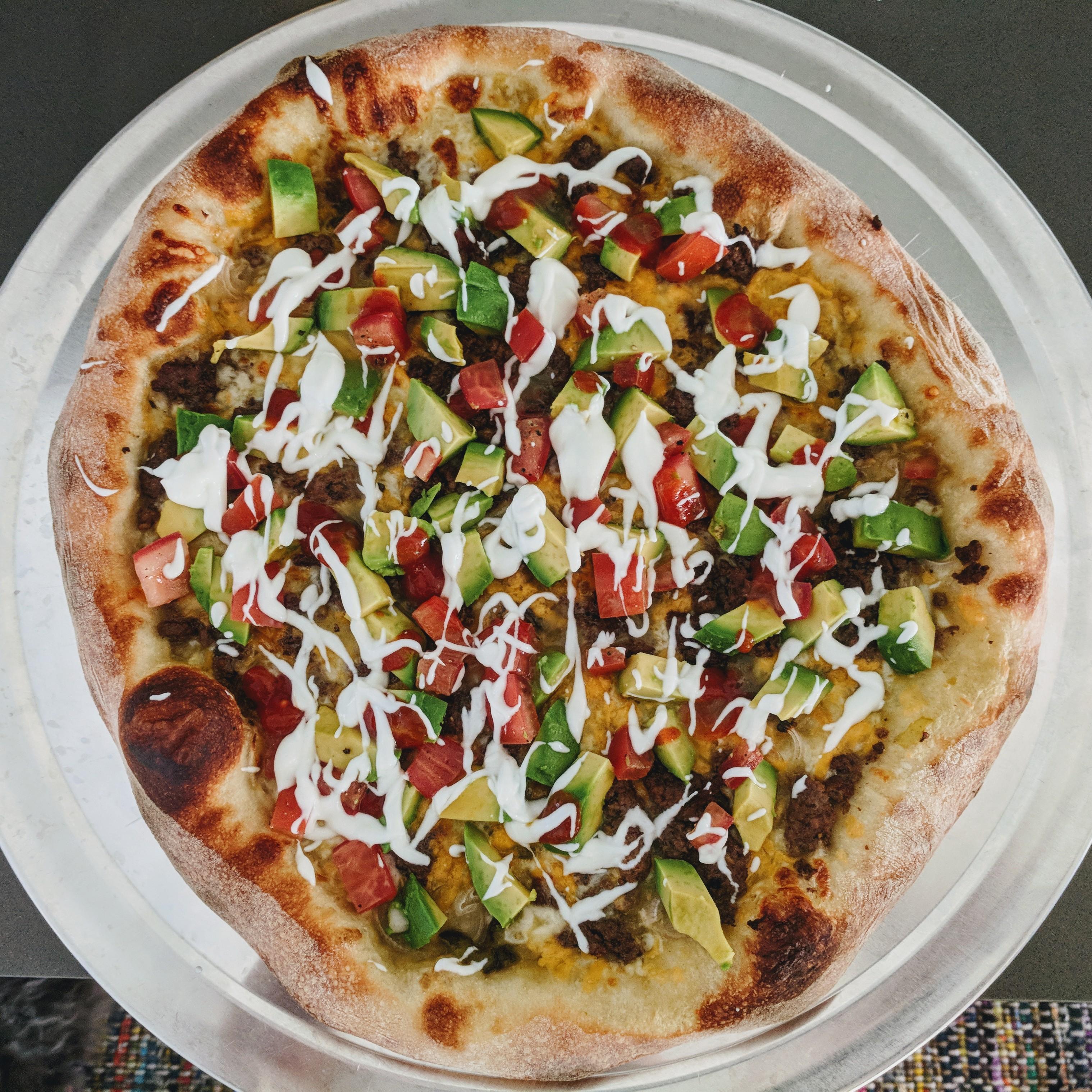 Taco pizza. Seasoned ground beef, shallots, roasted jalapeno, avocado