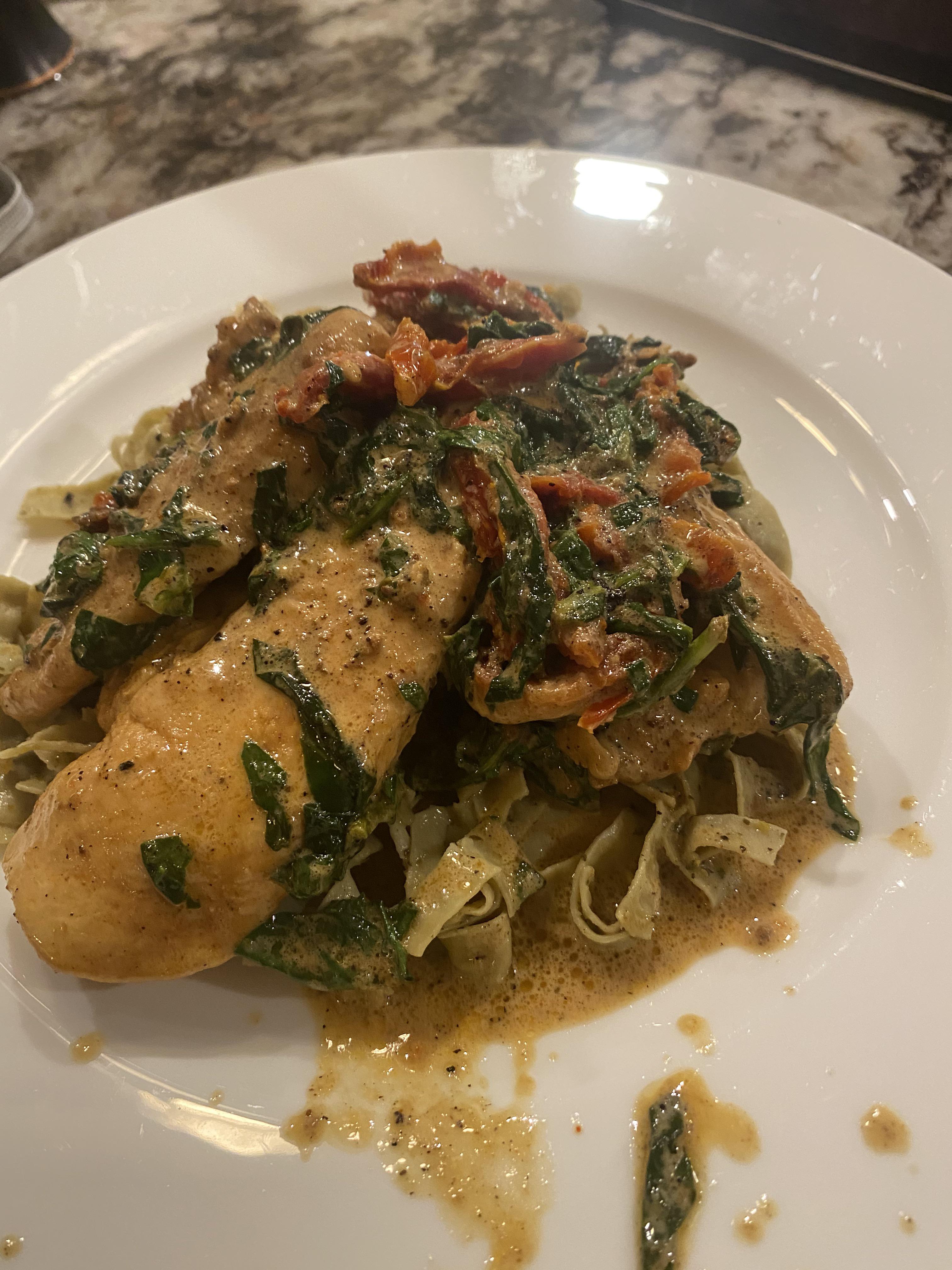 Creamy garlic chicken with Sun Dried tomatoes and spinach and a bed of