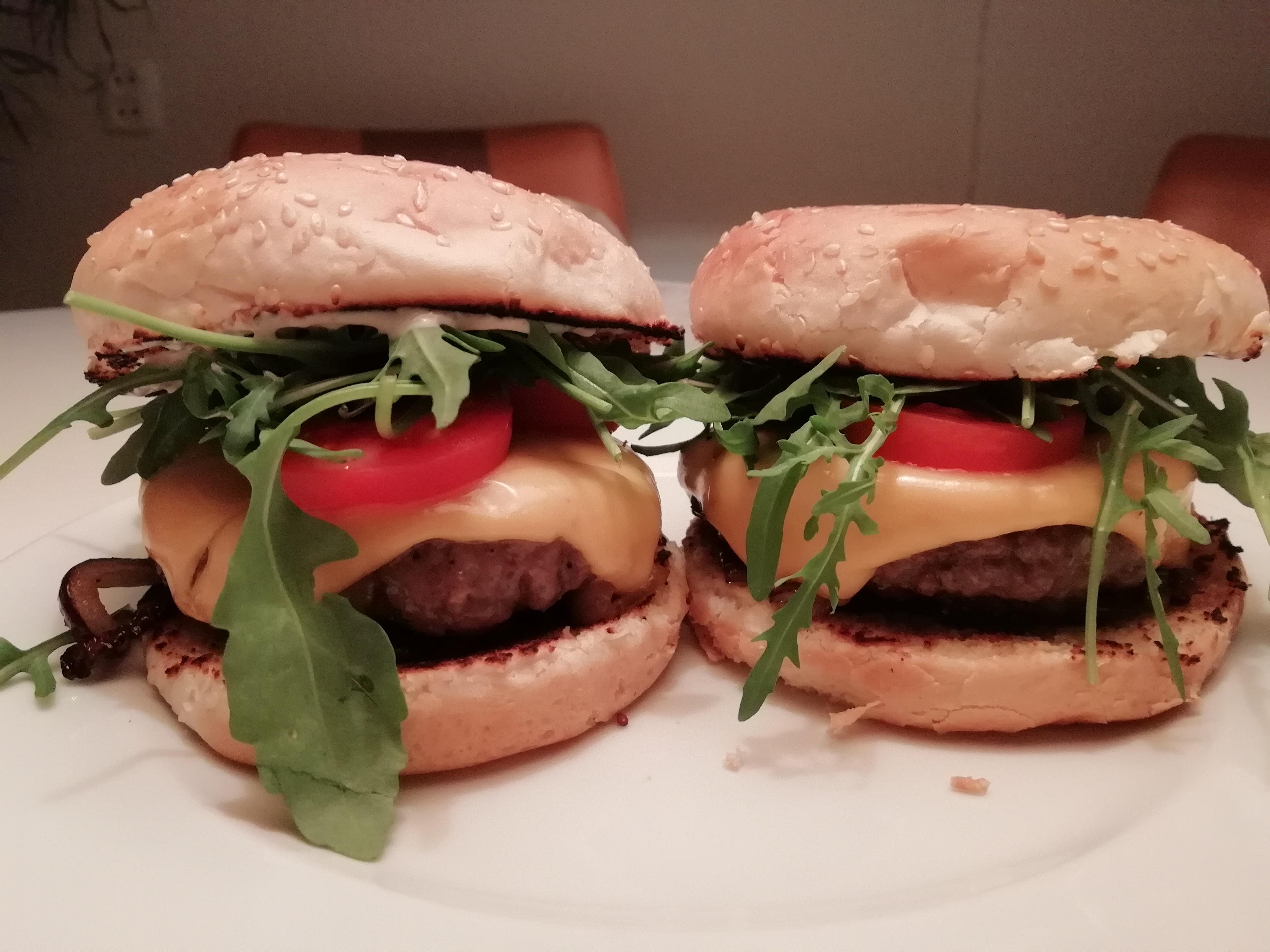 Burgers with caramelised onions, cheddar cheese, rocket, tomatoes and