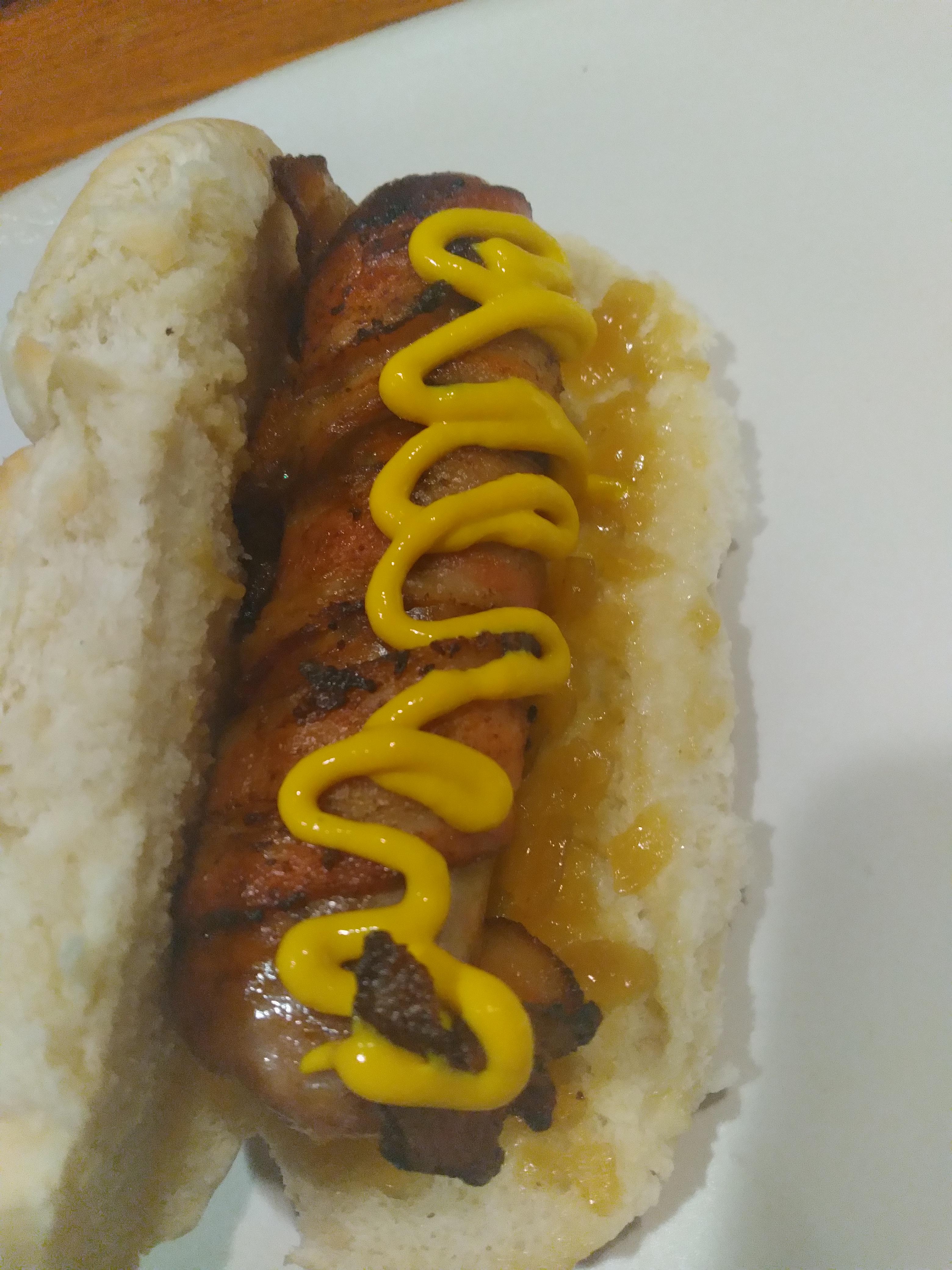 jalapeño cheddar bratwurst wrapped in bacon on a fluffy bun with